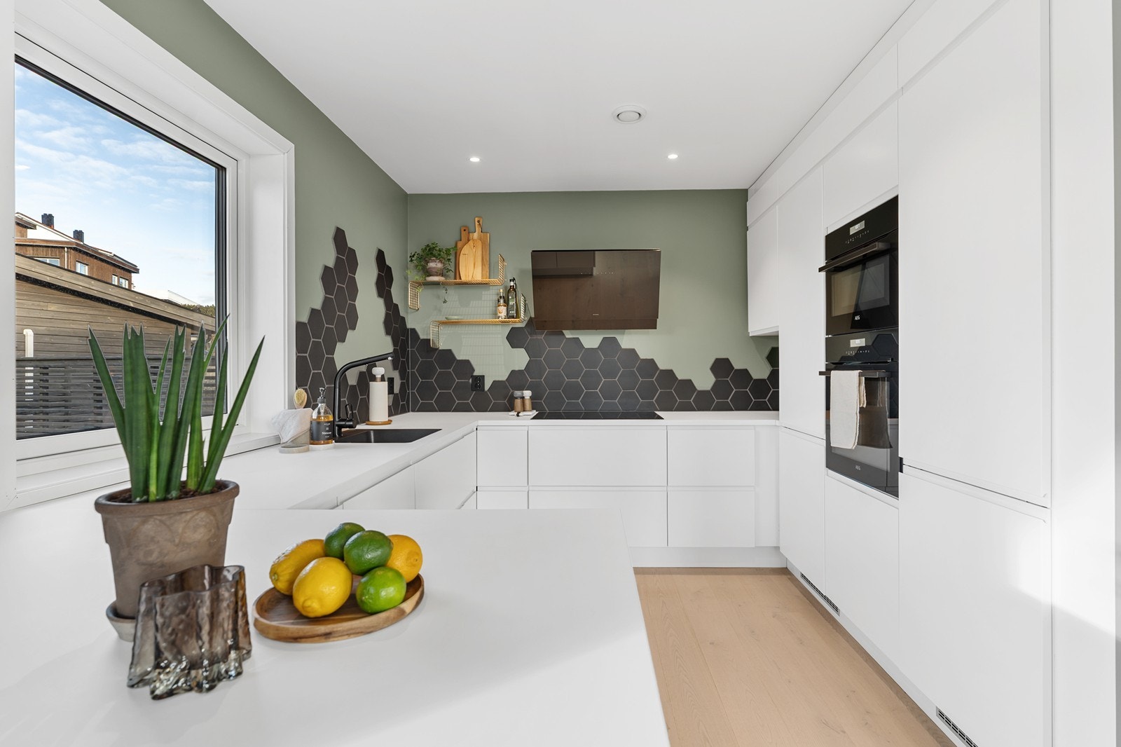 Kjøkkenet har stilren innredning med hvite fronter og laminert benkeplate. Galleribilde