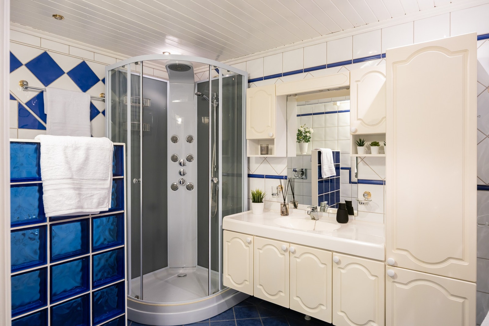 Flislagt baderom i kjelleretasjen med gulvvarme, toalett, dusjkabinett, servant og baderomsinnredning. Galleribilde