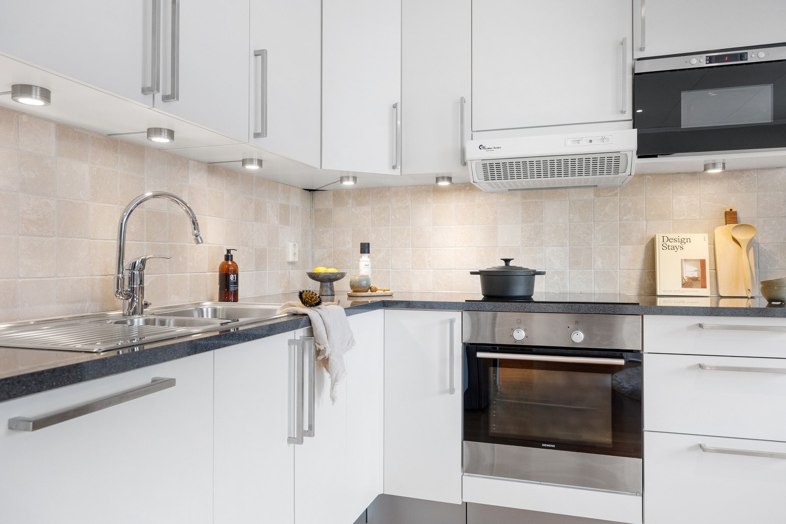 Kjøkkenet er tidløst innredet med slette fronter og laminert benkeplate Galleribilde