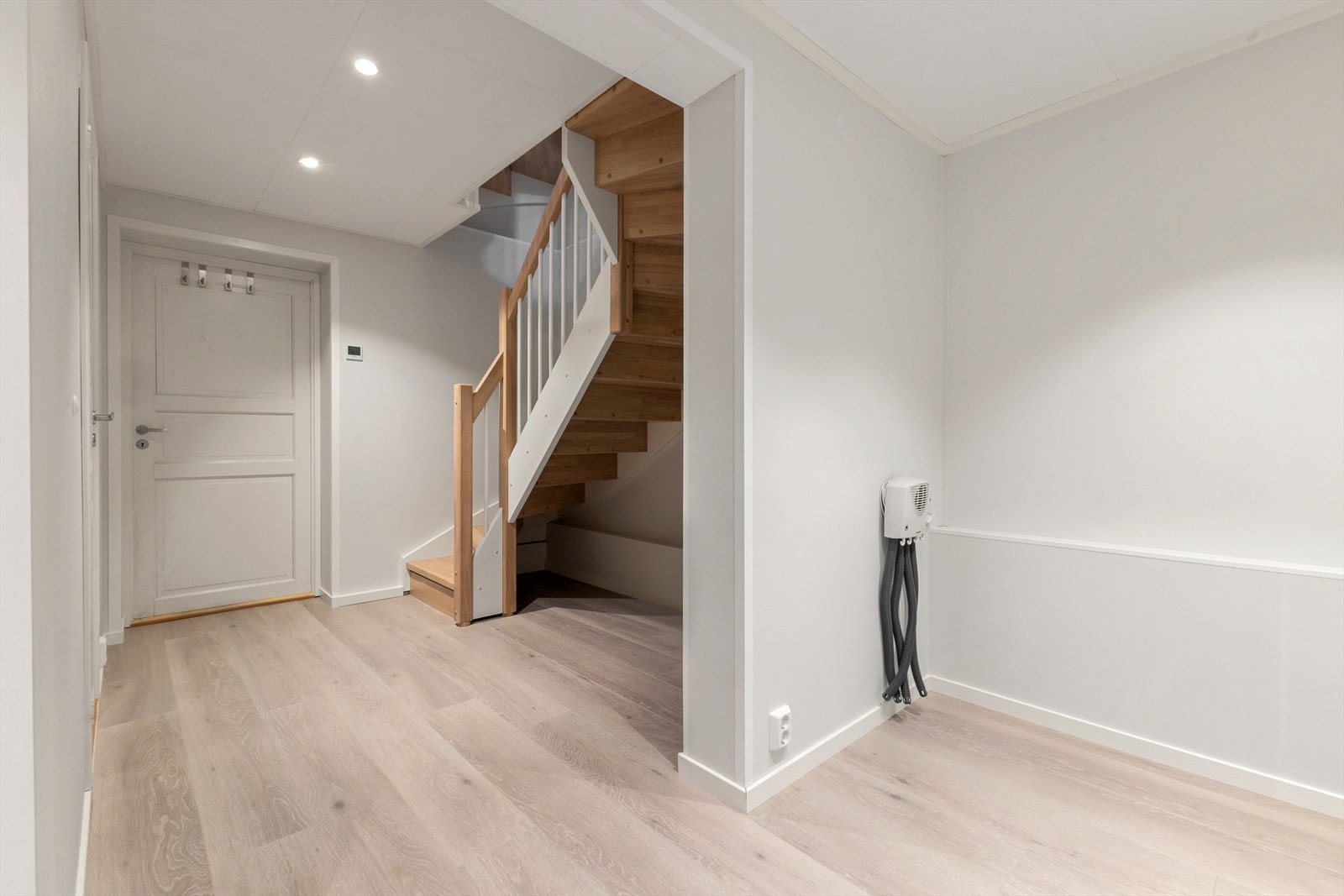 Trappegang/hall. Downlights i himling. Døren rett frem, fører til stort uinnredet rom med både vann og avløp. Galleribilde