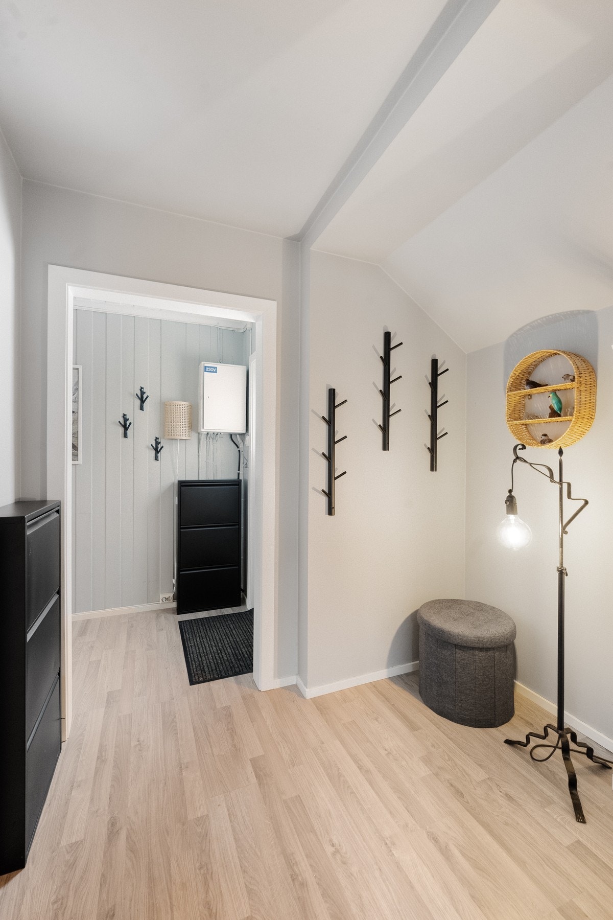 Videre inn i gangen er det glatte, malte overflater og nytt laminatgulv fra 2023. Her er det godt med plass til yttertøy og sko - en praktisk og ryddig løsning for en travel hverdag. Galleribilde