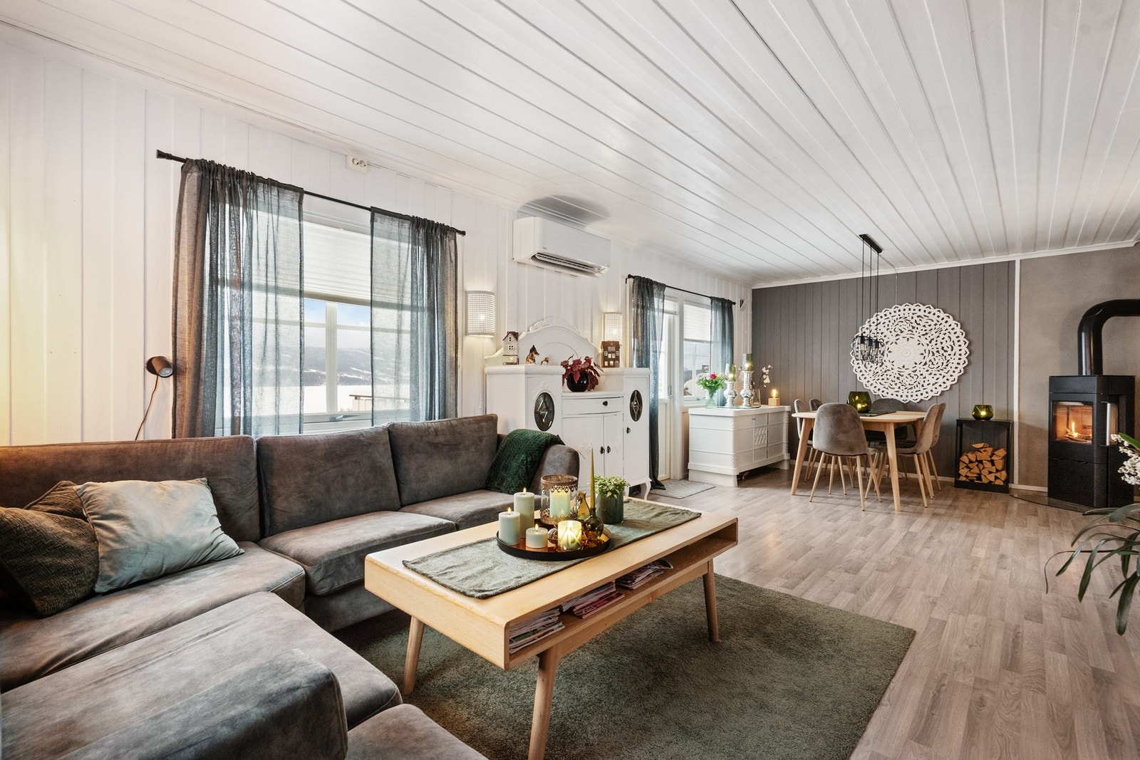 Peisovn fra 2022 skaper lun og behagelig atmosfære, mens varmepumpe fra 2018 bidrar til effektiv oppvarming året rundt. Galleribilde