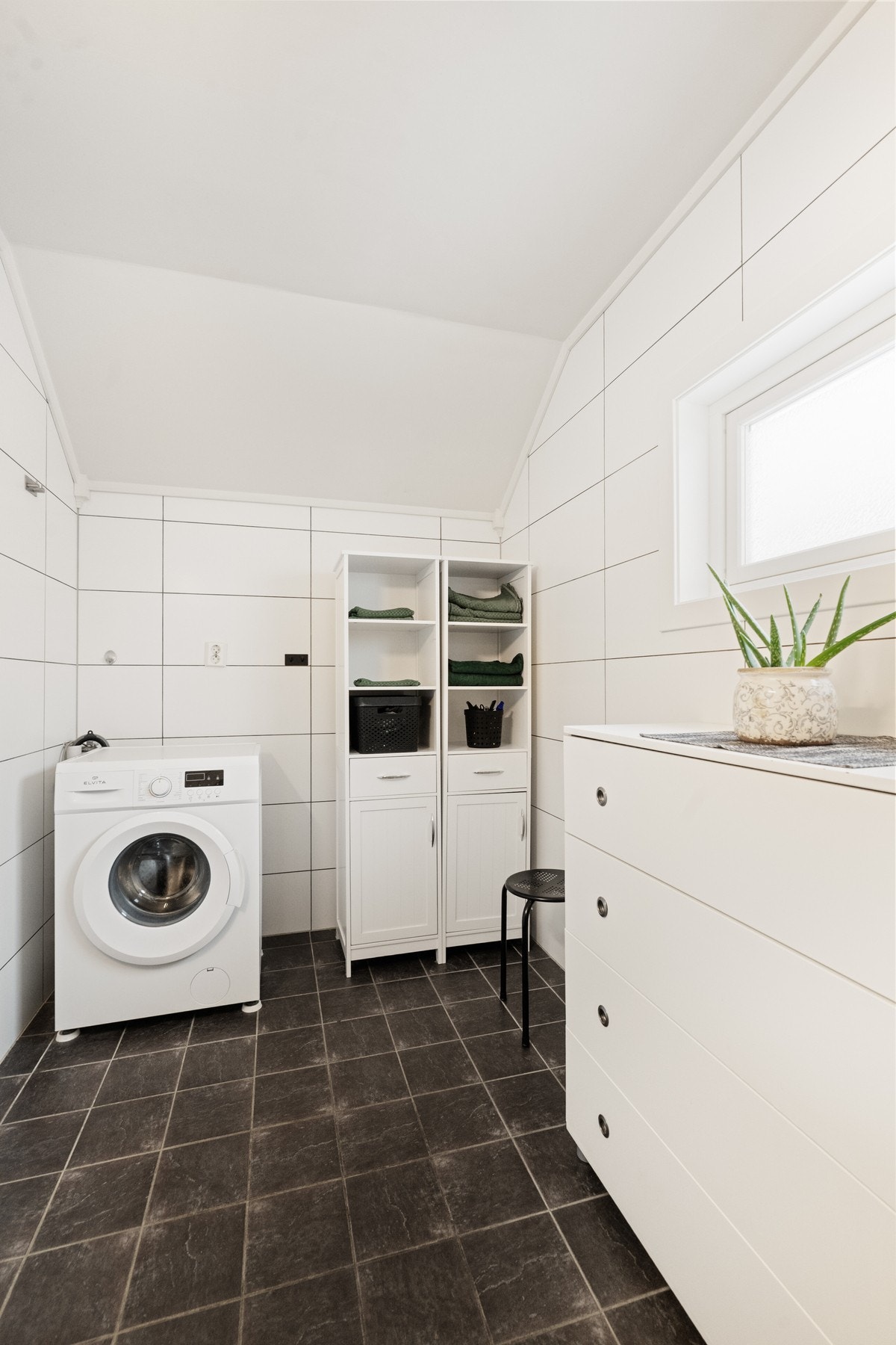 Rommet har gulvmontert toalett, opplegg for vaskemaskin, elektriske varmekabler i gulv og ventilasjon via el-avtrekk på yttervegg. Galleribilde