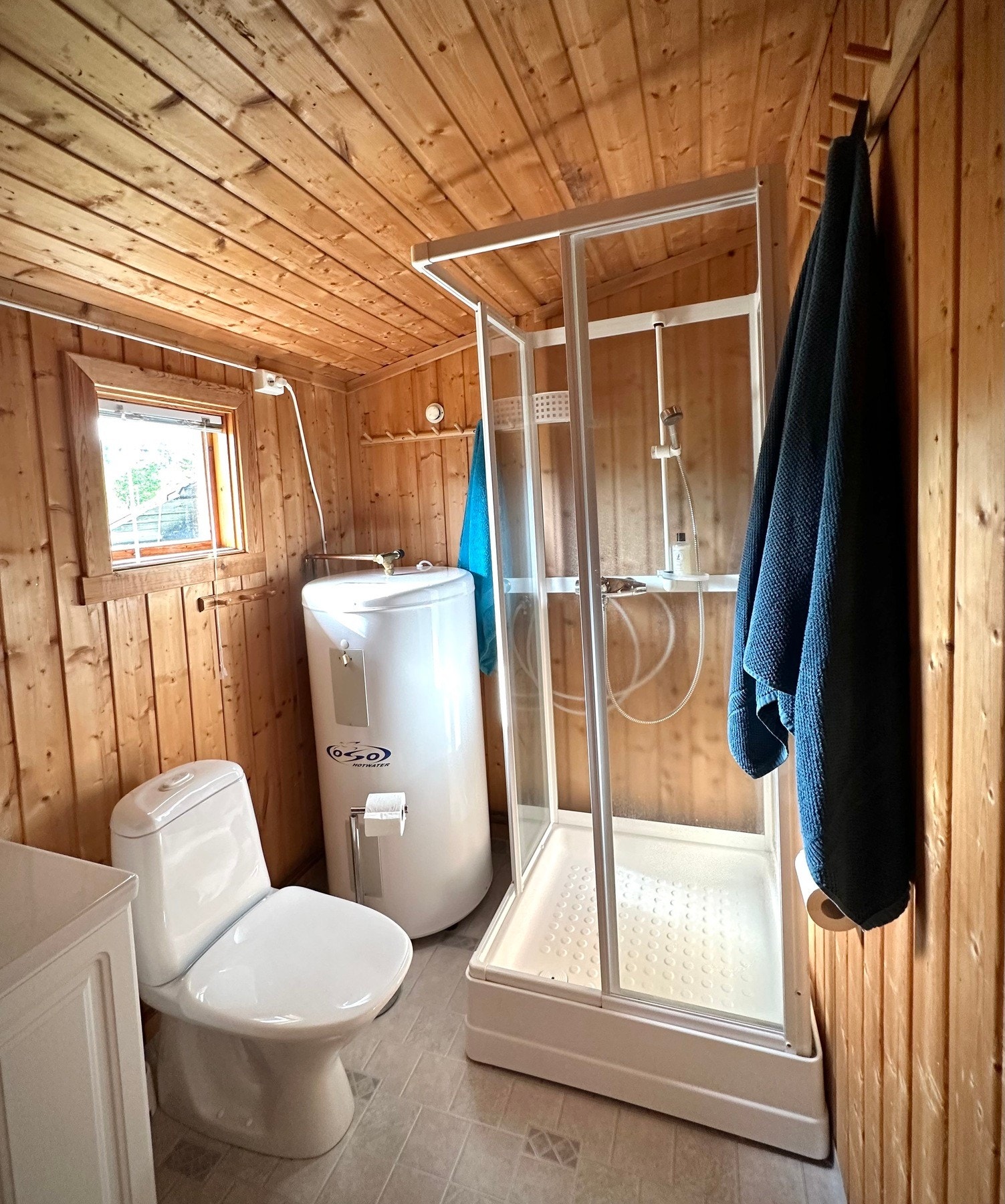 Badet har belegg på gulv, panel på vegger og i himling. Badet er utstyrt med innredning med servant, toalett og dusjkabinett. Galleribilde