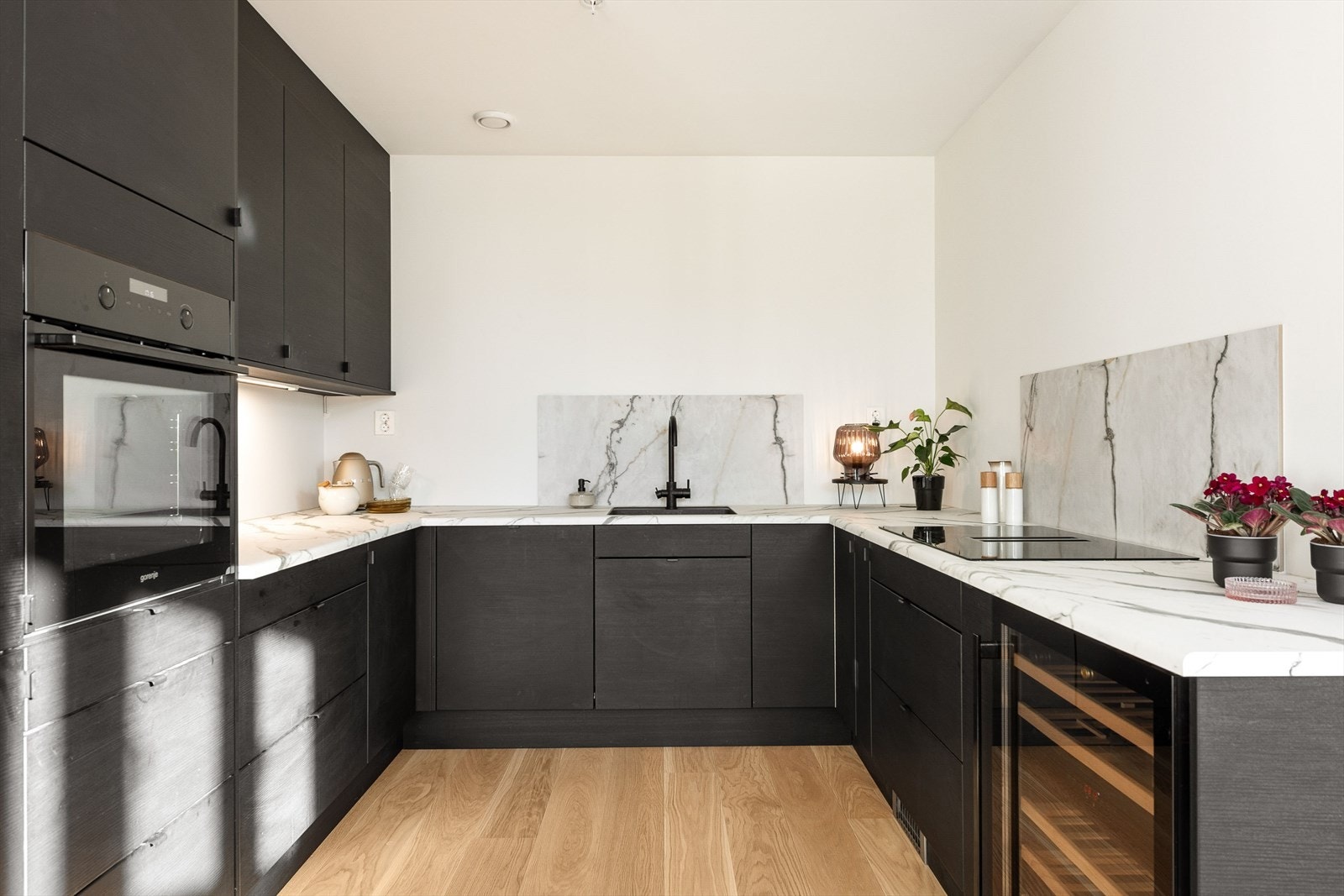 Delikat kjøkken med sorte, slette fronter og laminert benkeplate Galleribilde