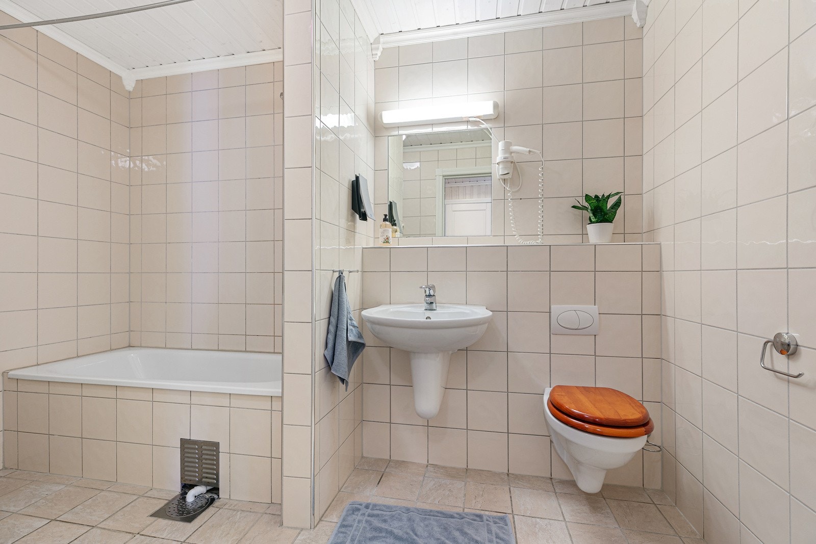 Bad i underetasje med gulvvarme, badekar, toalett og opplegg for vaskemaskin. Galleribilde