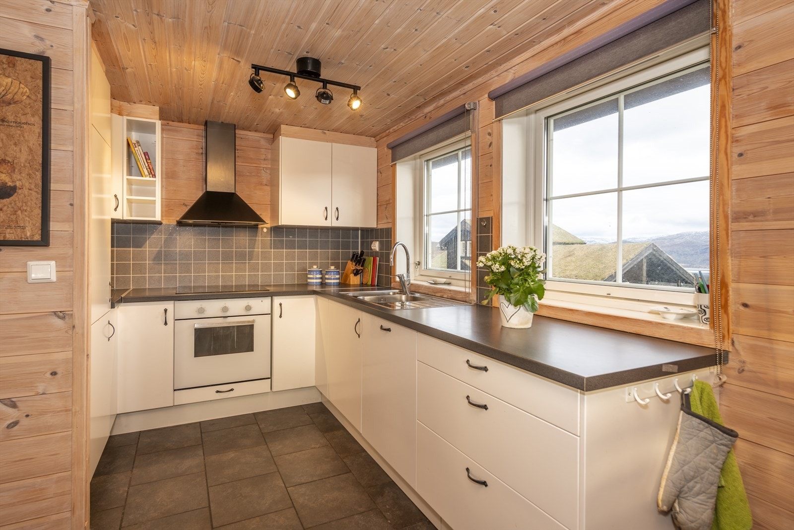 Stilrent kjøkken med laminat benkeplate og integrerte hvitevarer som følger handelen. Galleribilde