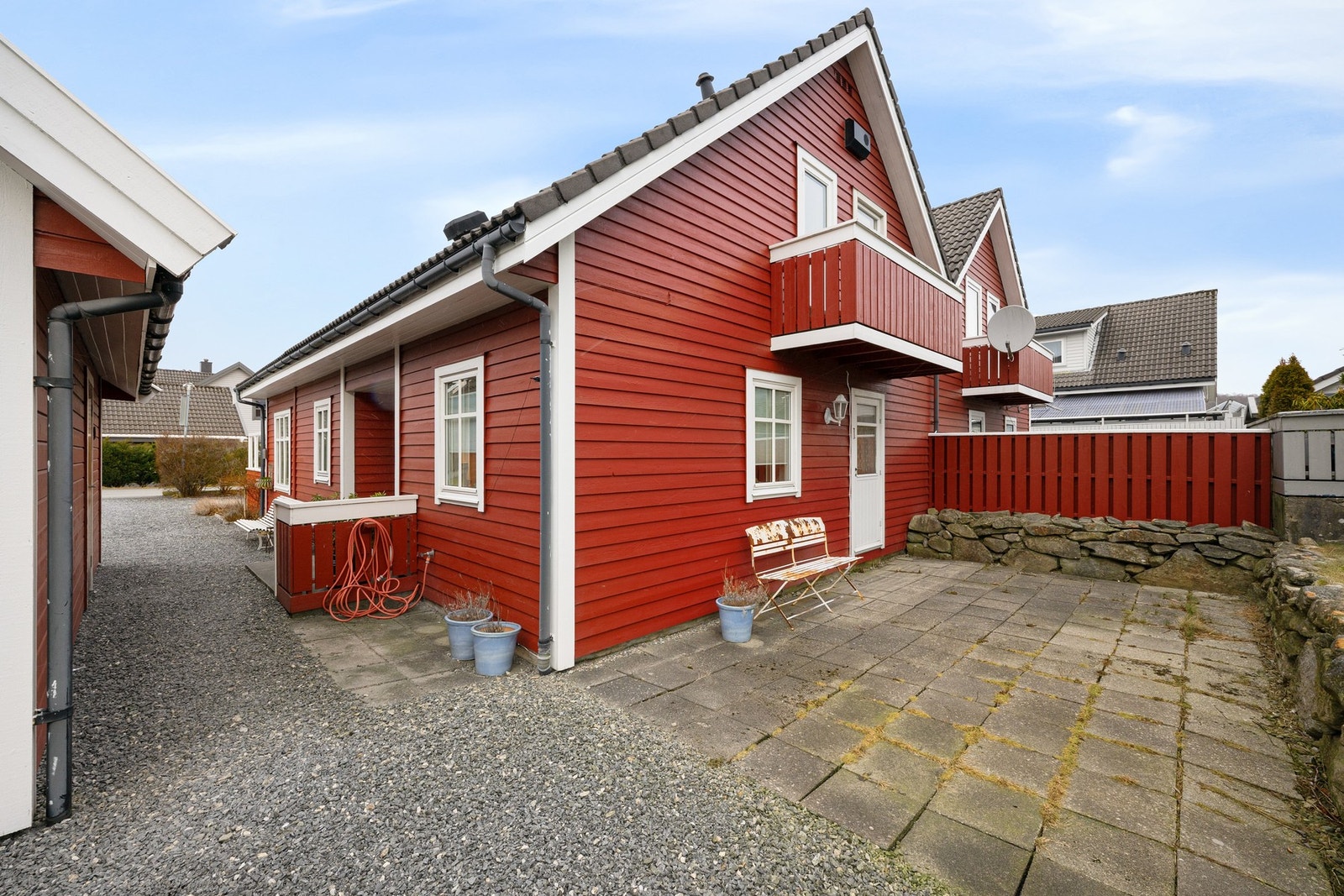 Bakside med biinngang og hellebelagt uteplass Galleribilde