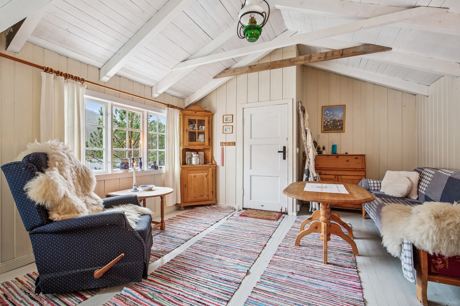 Rommet har vindusflater som slipper inn godt med dagslys og gir kontakt med naturen rundt hytta. Galleribilde