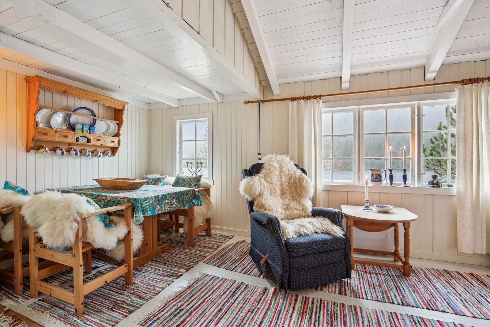 Åpen stue/kjøkken-løsning med furugulv, trepanel på vegger og himling - en klassisk og rustikk hyttestil som gir god hyttefølelse. Galleribilde