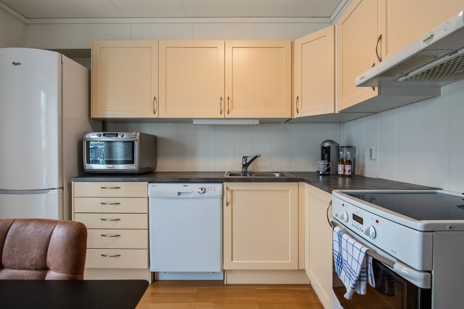 Innredningen har profilerte fronter, laminerte skrog og en laminert benkeplate med nedfelt kjøkkenkum. Galleribilde