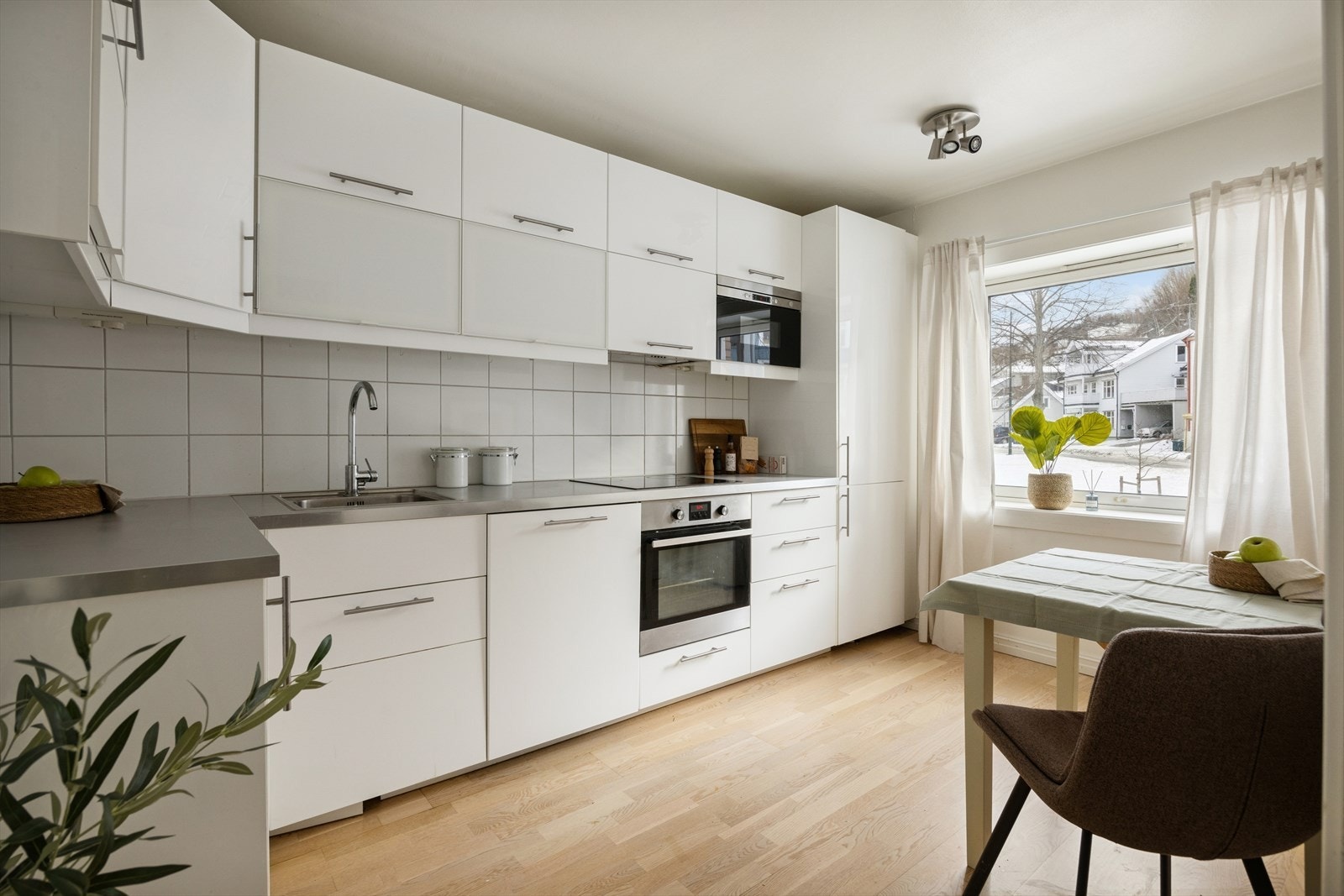 Romslig kjøkken med god skap- og benkeplass, samt plass til spisebord. Galleribilde