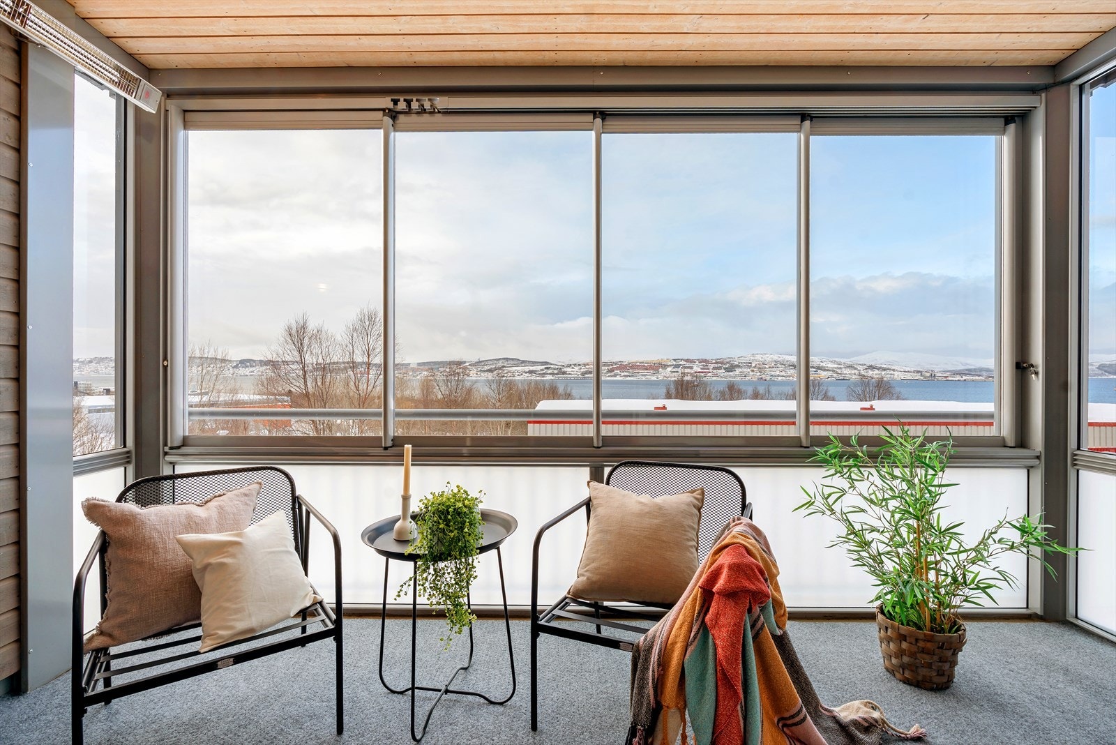 Innglasset vestvendt balkong utstyrt med varmelampe og vinduer som kan åpnes til siden. Galleribilde