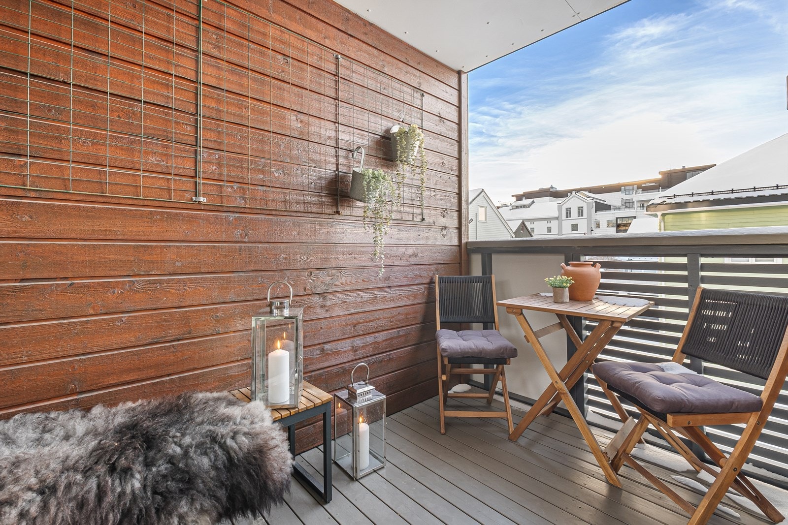 Balkongen er tilbaketrukket og overbygget, så her sitter du god i le for vær og vind Galleribilde