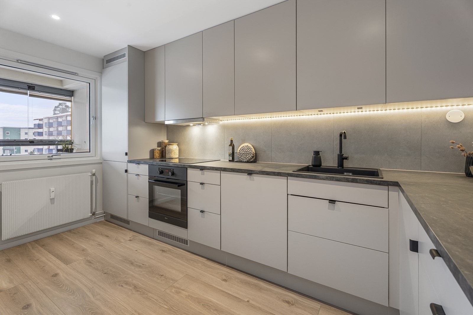 Kjøkkenet fra 2023 har en stilren Epoq-innredning med glatte fronter og en laminert benkeplate. Galleribilde