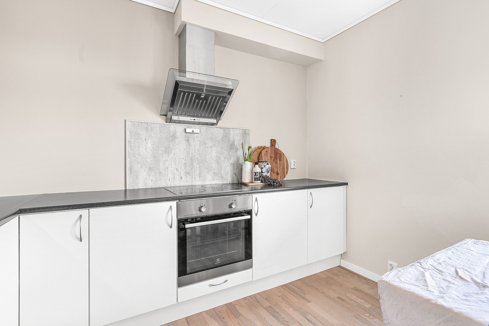 Kjøkkenet er innredet med slette hvite fronter, laminat benkeplate og integrerte hvitevarer. Galleribilde