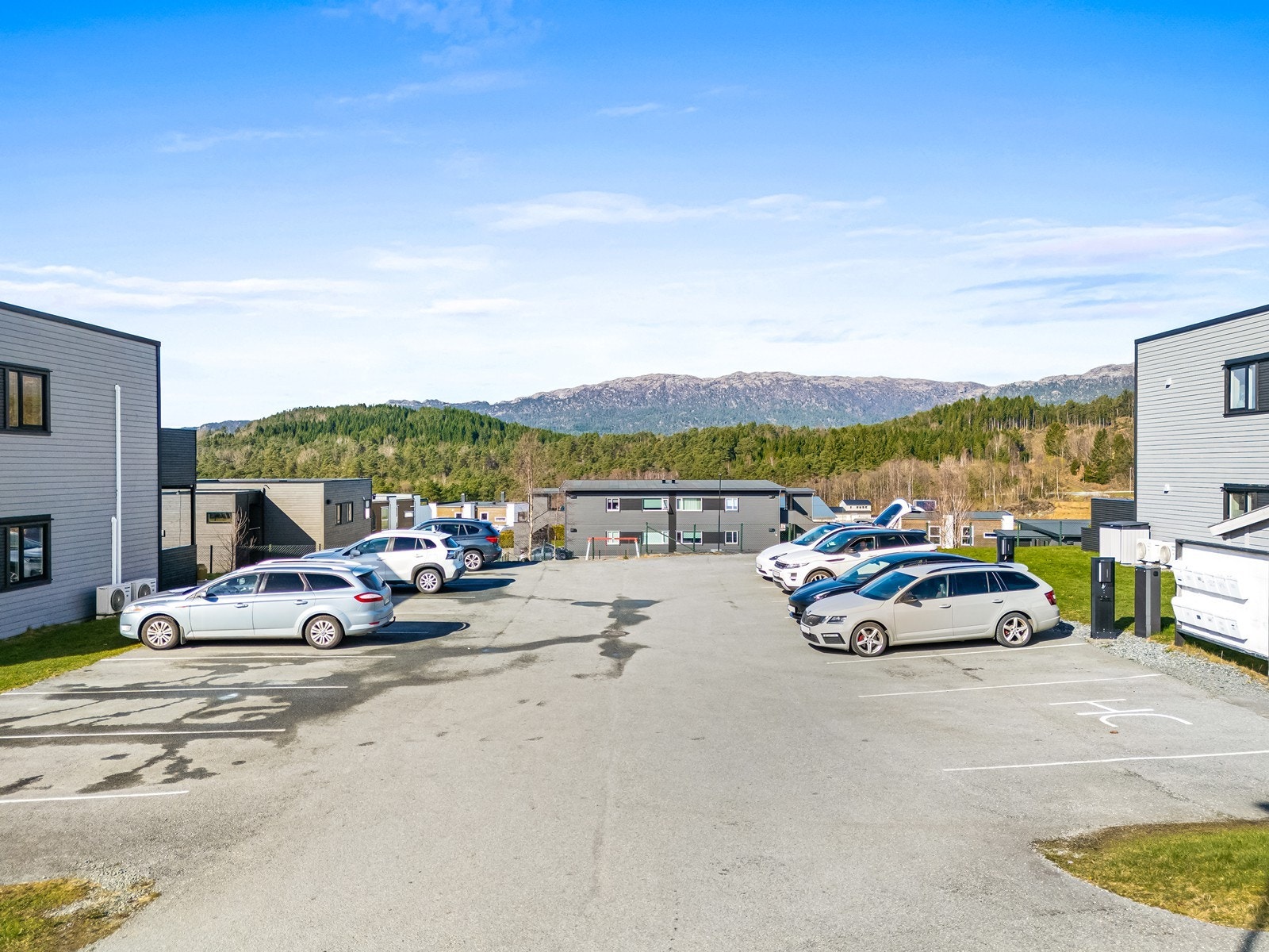 Parkeringsplass på sameiets tomt hvor det også er satt opp el-bil ladere. Galleribilde