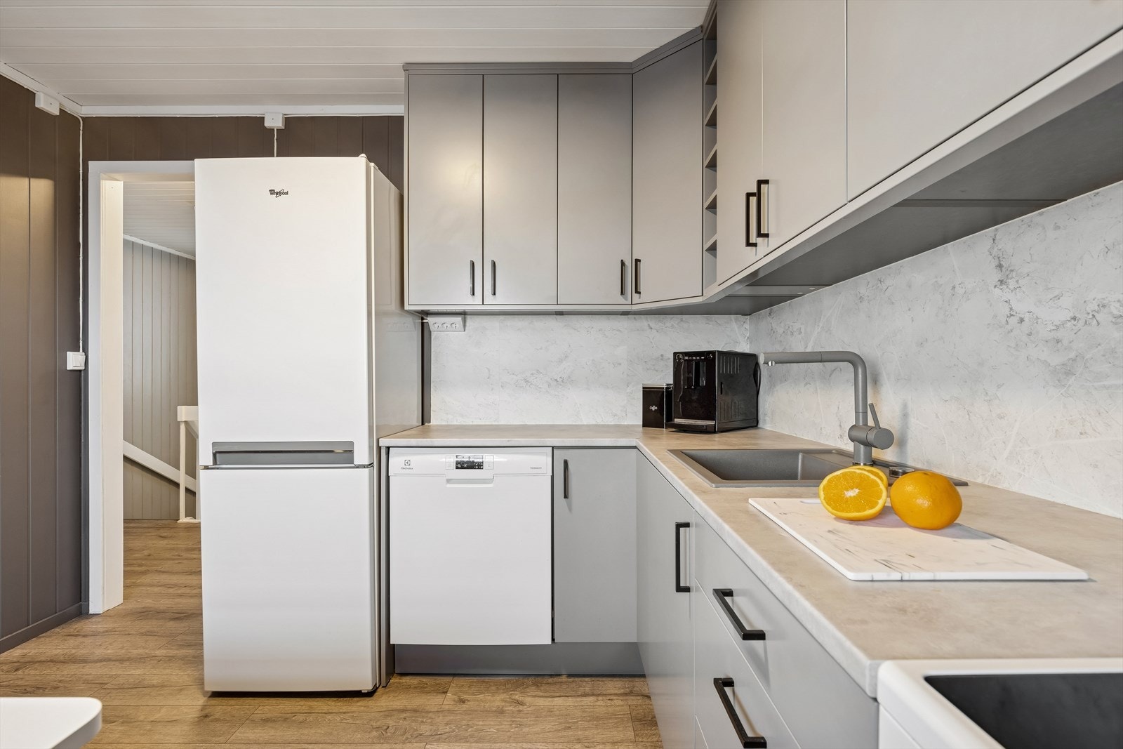 Innredningen har glatte fronter, laminert benkeplate og nisjer for hvitevarer. Galleribilde