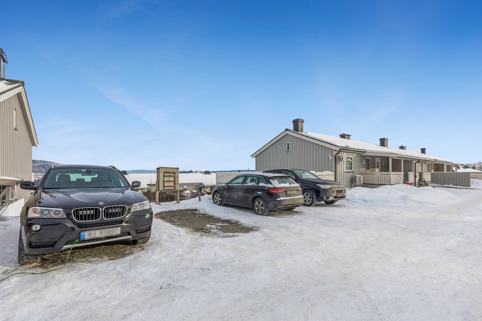 Boligen disponerer to biloppstillingsplasser - en i rekke og en foran inngansdøren med elbillader, i tillegg til en garasjeplass forberedt for elbillading. Galleribilde