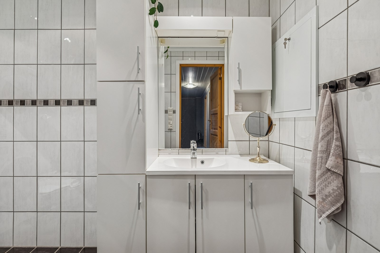 Baderomsinnredning med dekkende servant og speilskap. Galleribilde