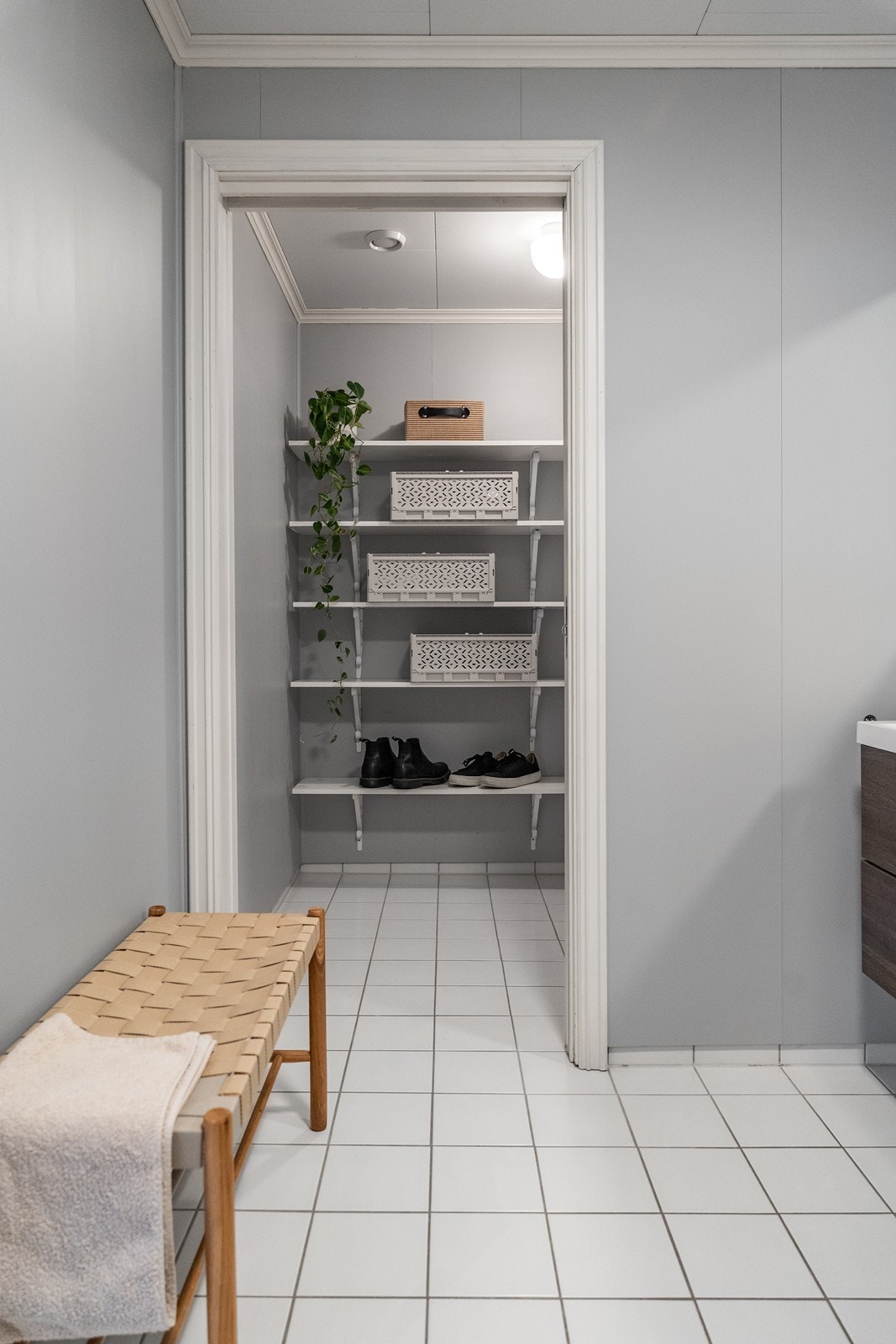 Fra badet er det adkomst til et praktisk vaskerom med opplegg for vaskemaskin og god oppbevaringsplass i hylleinnredning. Galleribilde