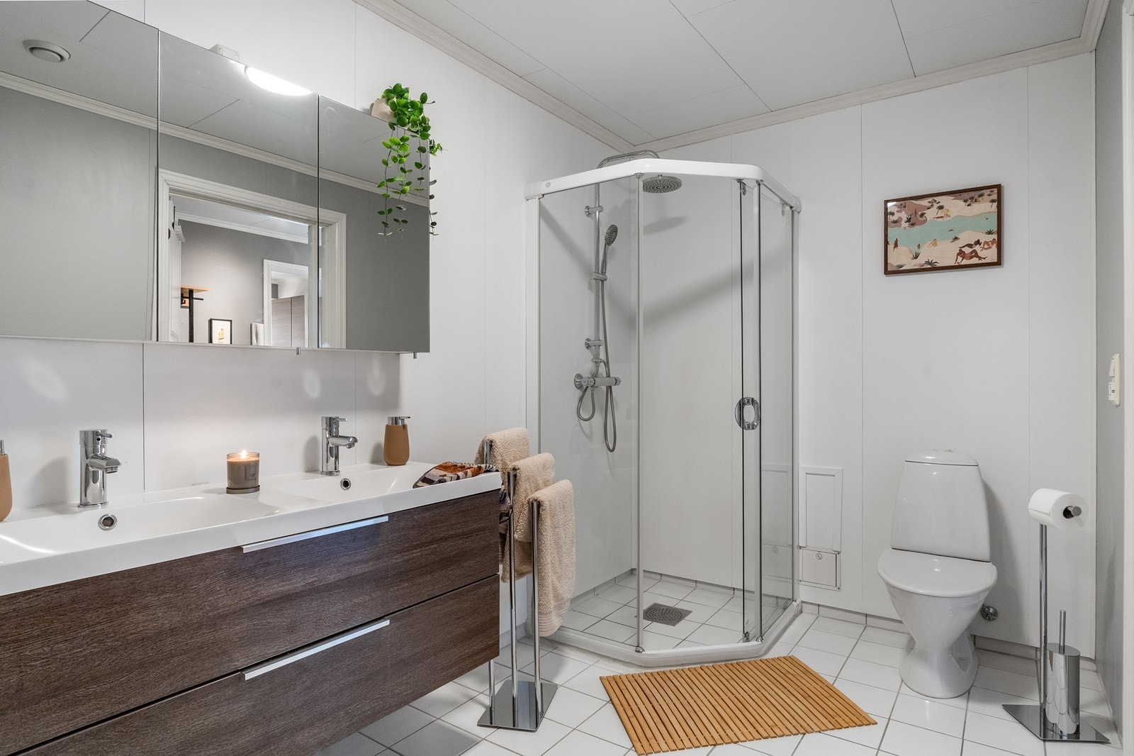 Badet har våtromsplater på veggflater og fliser på gulv. Det er varmekabler i gulv. Galleribilde