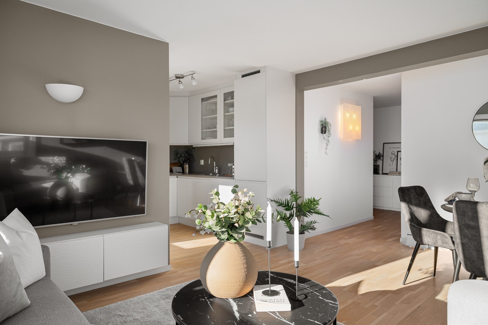 Det er stue og kjøkken i åpen løsning med plass til sofa og spisebord. Galleribilde