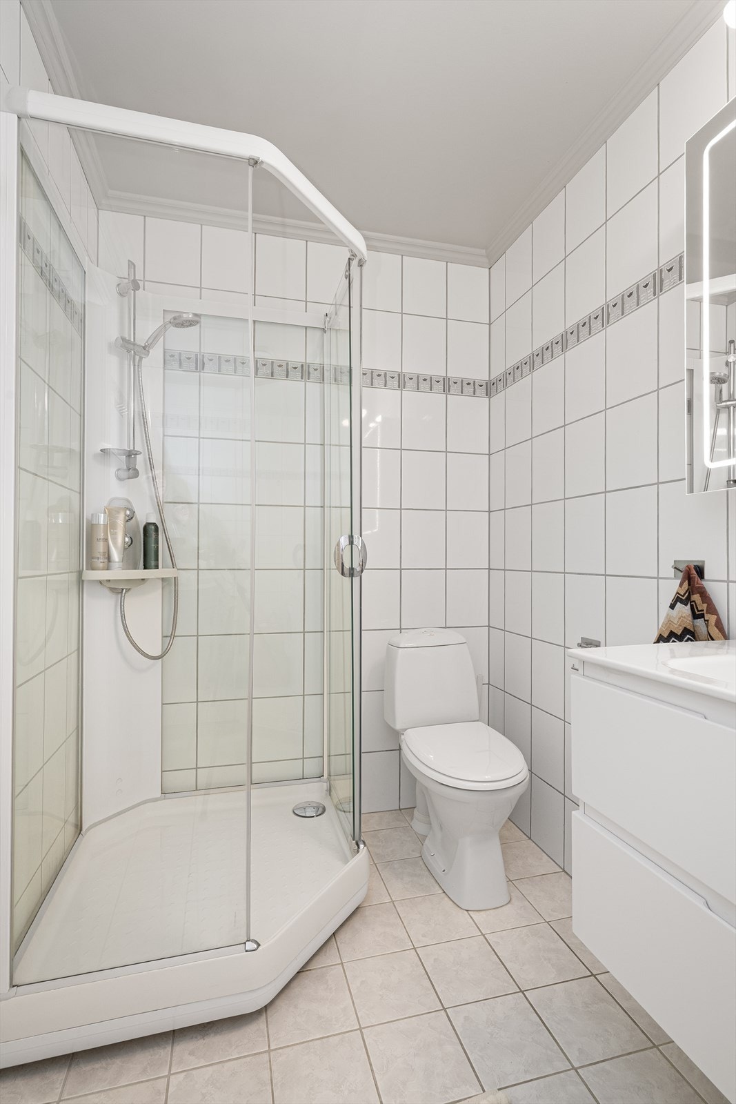 Badet har varmekabler, toalett og dusjkabinett, samt opplegg for vaskemaskin. Varmtvannstank på ca. 120 liter er montert i kjøkkeninnredning. Galleribilde