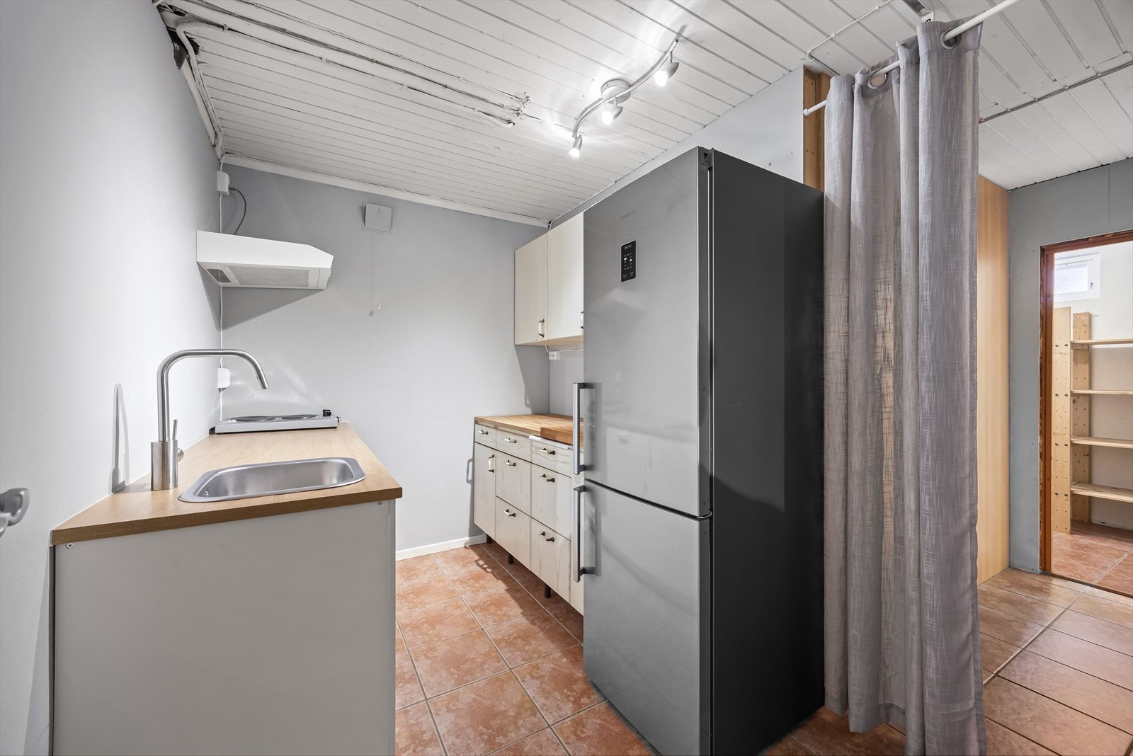 Kjelleretasjen har kjøkken. Kjøkken har innredning bestående av glatte fronter, benkeplate og nedfelt kum i rustfritt stål, samt opplegg for oppvaskmaskin. Galleribilde