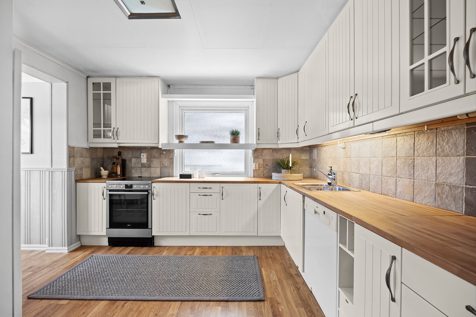 Tilbake i boligen tar vi turen til kjøkkenet. Kjøkkenet ligger i et eget rom og er av god størrelse med rikelig skap- og benkeplass. Galleribilde