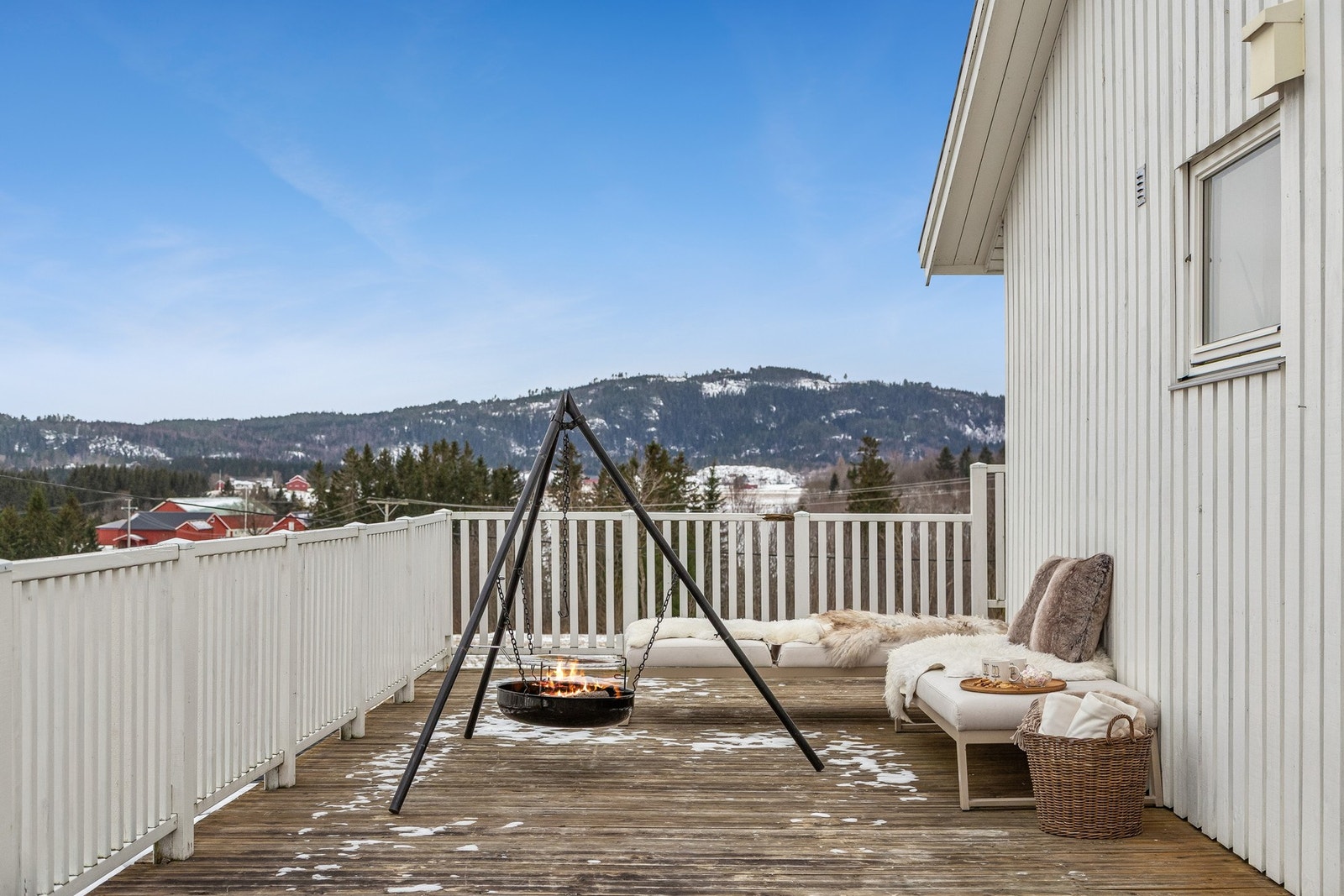 Terrassen går rundt store deler av boligen hvor den har tilgang til stuen, vaskerommet og hovedsoverommet Galleribilde