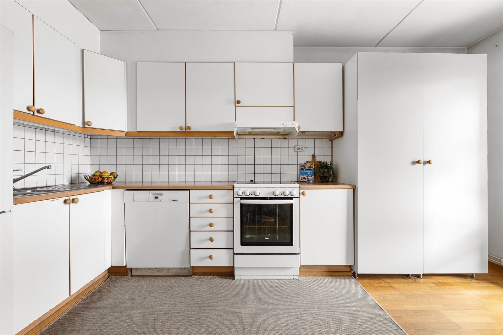 Delvis åpen kjøkkenløsning som har godt med benk- og skapplass Galleribilde