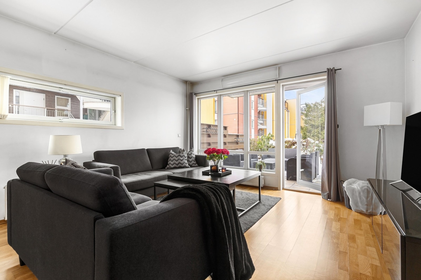 Leiligheten har en romslig stue med vindusflater på flere kanter som sørger for at det kommer mye naturlig lys inn i boligen Galleribilde