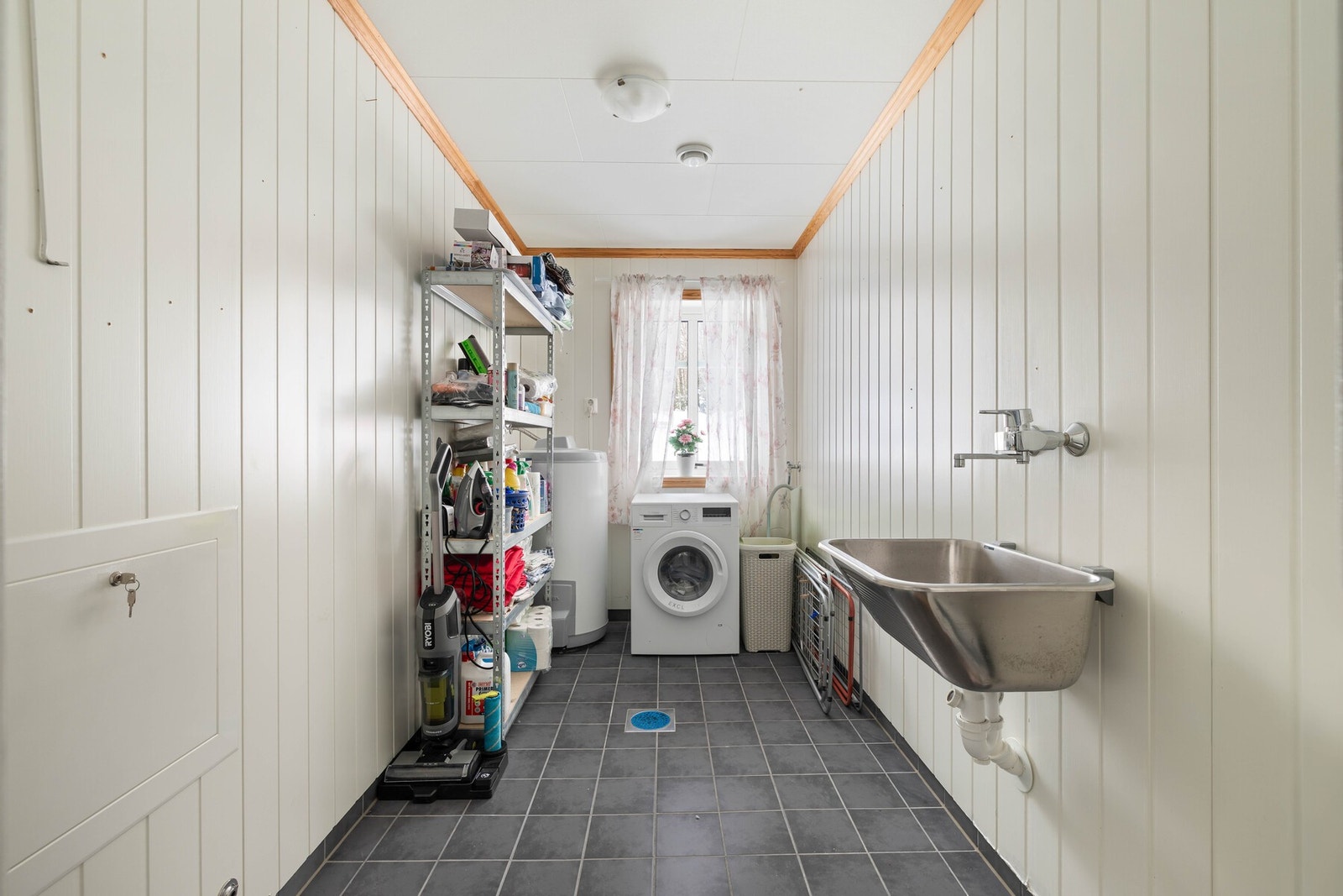 Vaskerommet er fra byggeår og har vaskekum og opplegg for vaskemaskin. Det er fliser på gulv, panelplater på vegger og plastsluk. Rommet har mekanisk ventilasjon med ventil i tak. Varmtvannsbereder på ca. 200 liter er plassert på vaskerom. Galleribilde