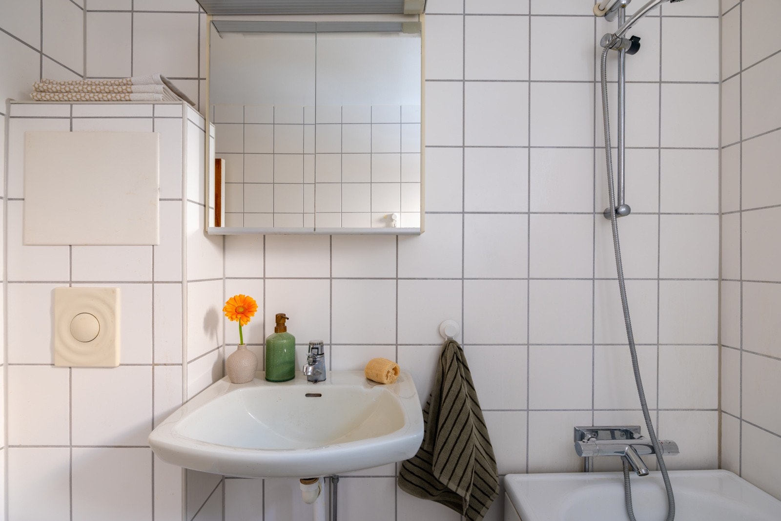 Badet har vegghengt servant, speilskap med overbelysning, badekar og vegghengt toalett. Galleribilde