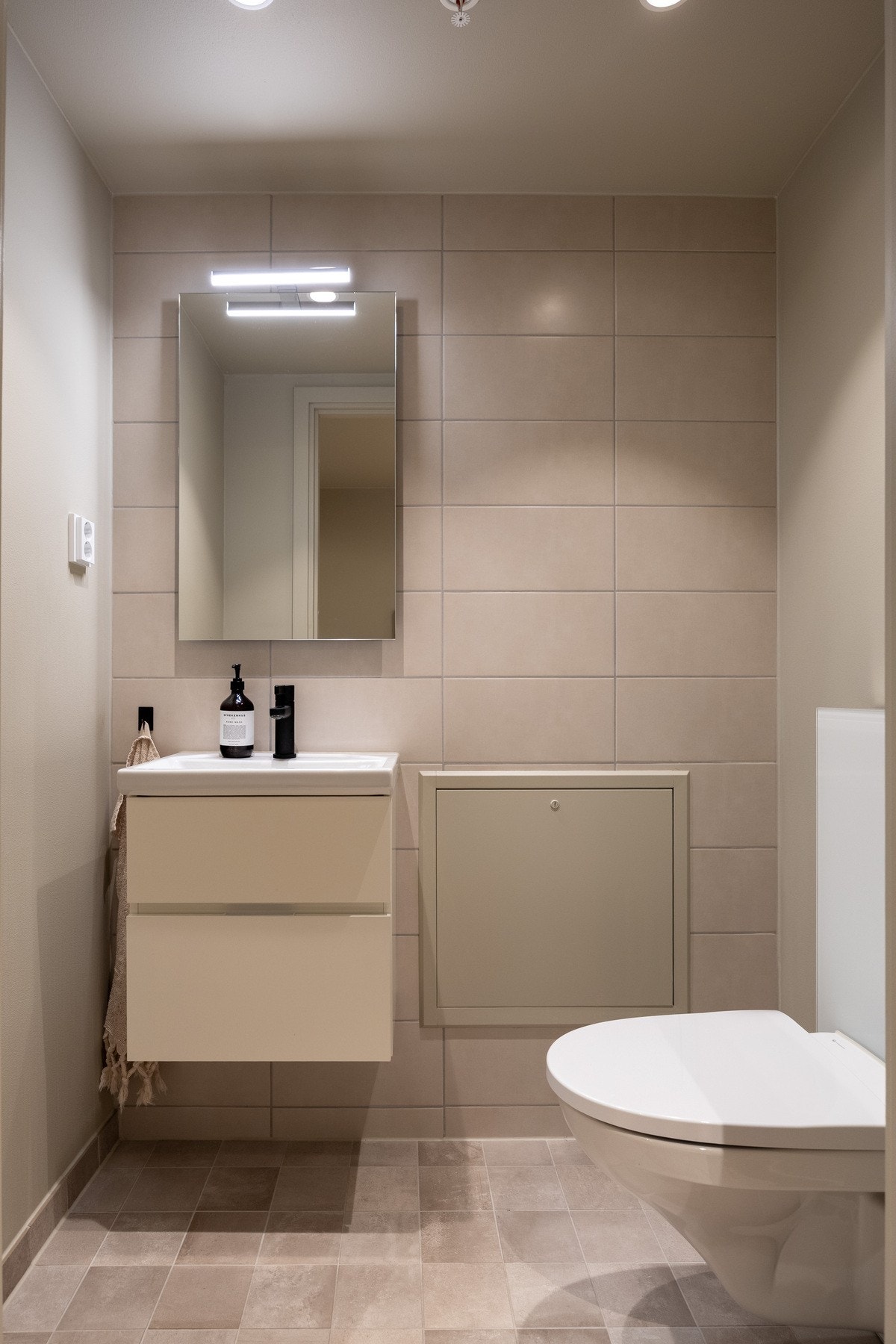 Praktisk ekstra toalett utstyrt med benkeskap/servant, speil over servant og klosett. Galleribilde