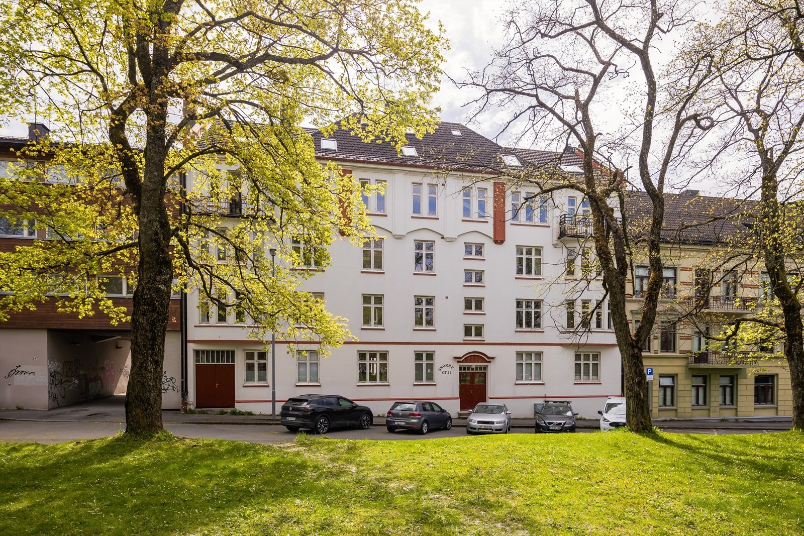 Sommerbilde av fasaden. Leiligheten ligger i 4. etasje og har lite innsyn. Det er mulighet for soneparkering like utenfor, til en kostnad på ca. 760 kr per måned. Det er også sykkelparkering i bakgården. Galleribilde