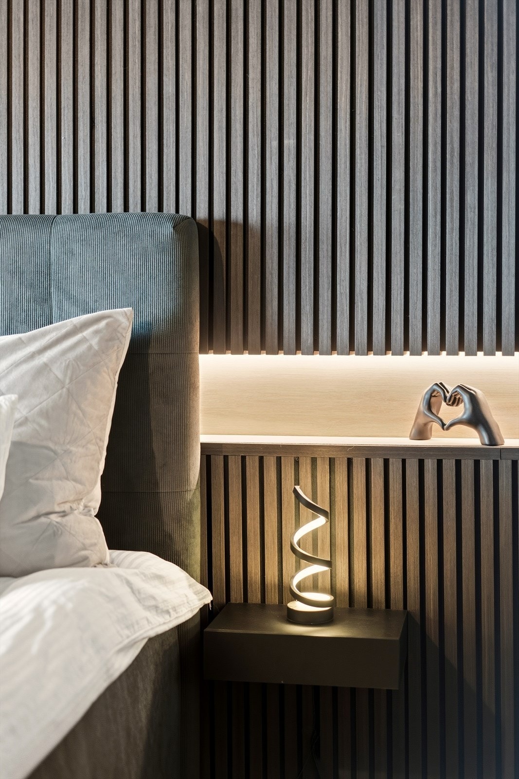 Rommet har en moderne spilevegg bak sengen. Galleribilde