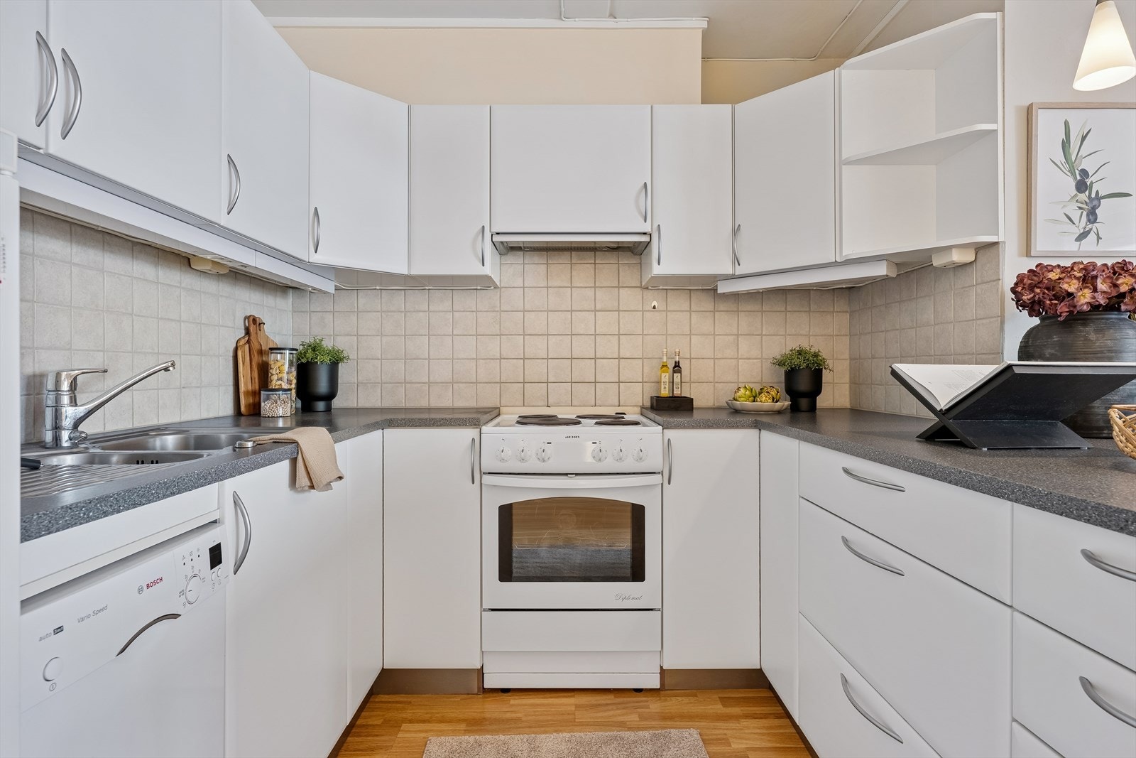 Det er flislagt over benken, og det er tilrettelagt for frittstående hvitevarer. Galleribilde