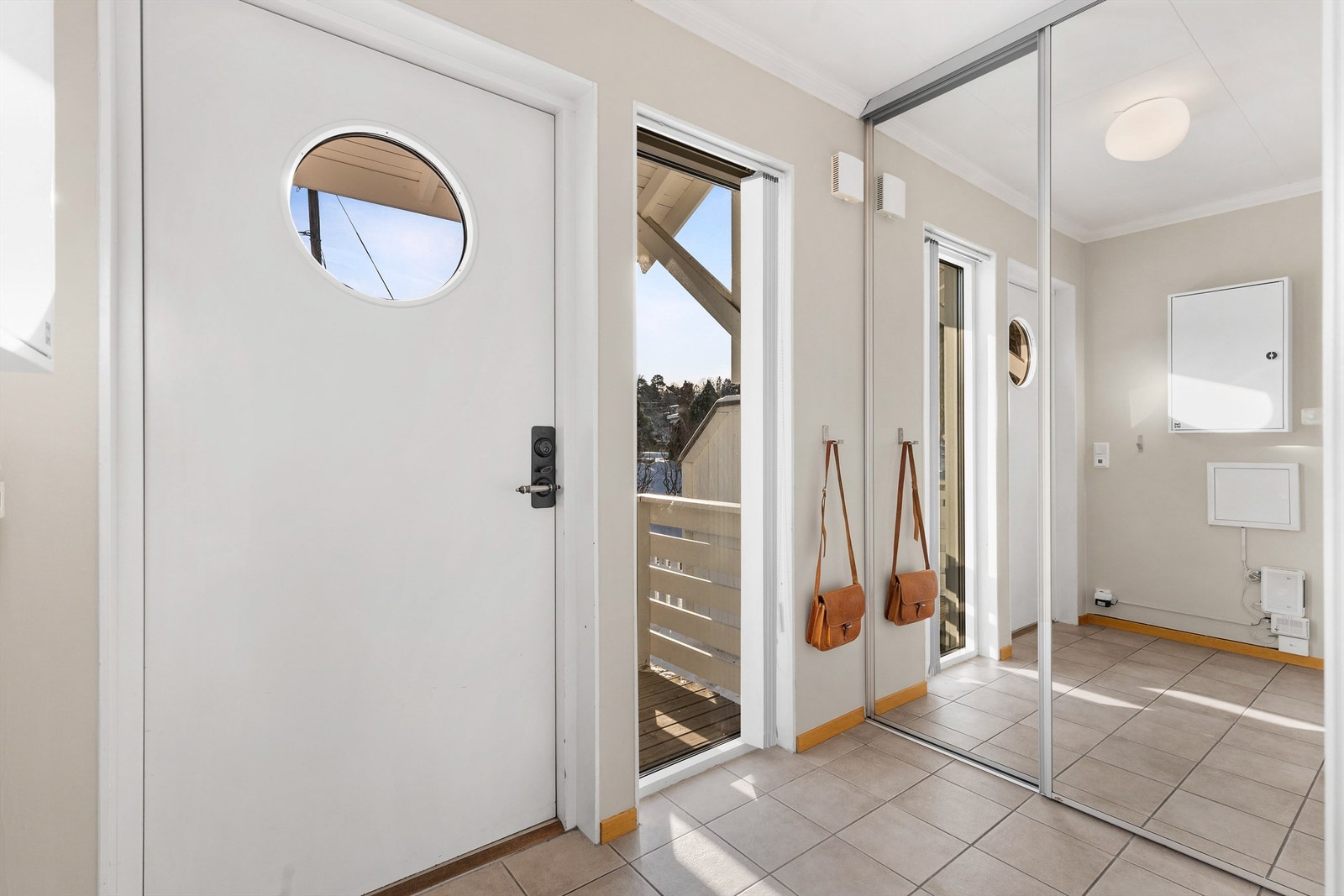 Entré med fliser på gulv og skyvedørsgarderobe. Galleribilde