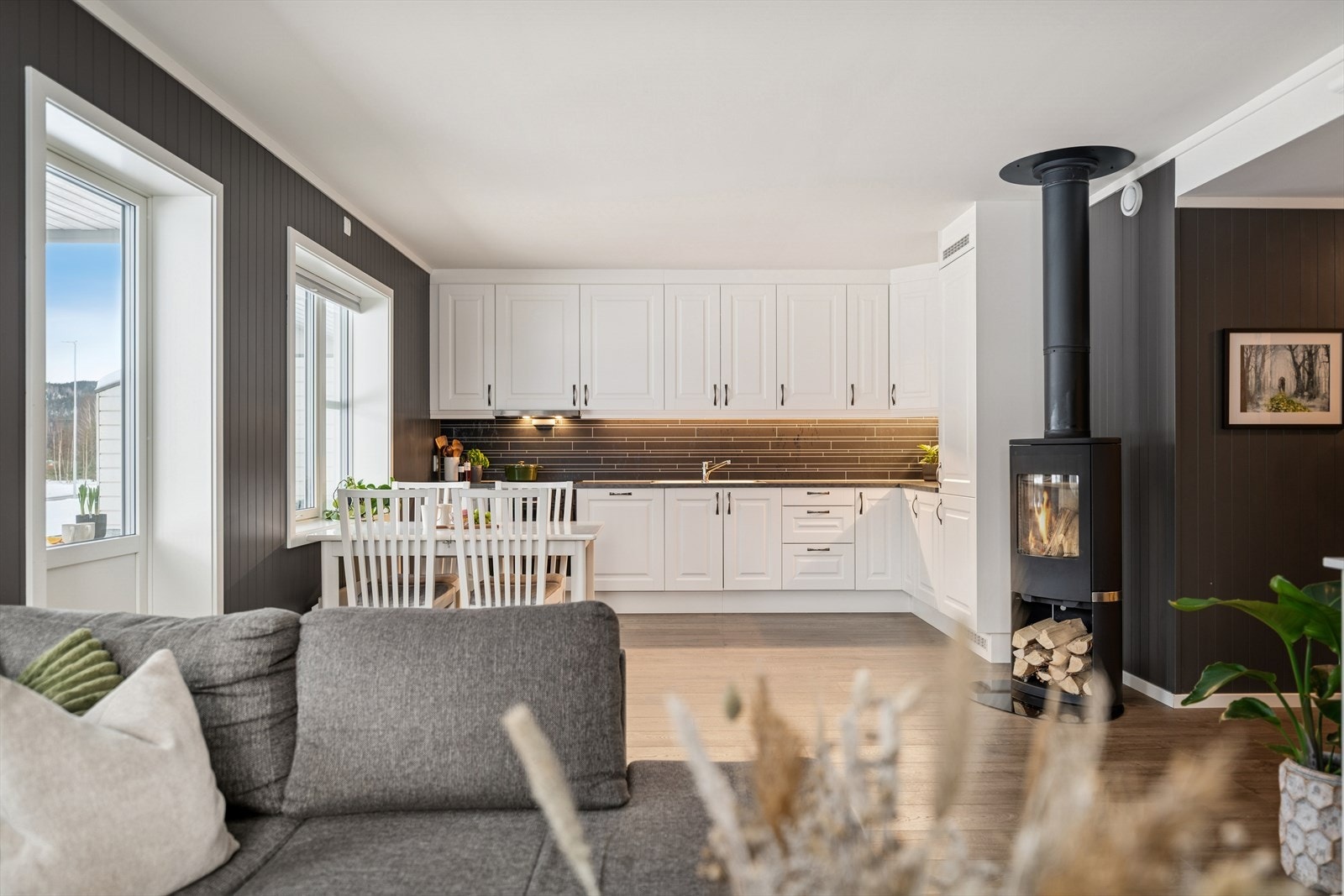 Stilren stue og kjøkkenløsning med laminatgulv og pene overflater. Den åpne utformingen gir en harmonisk og innbydende atmosfære. Galleribilde