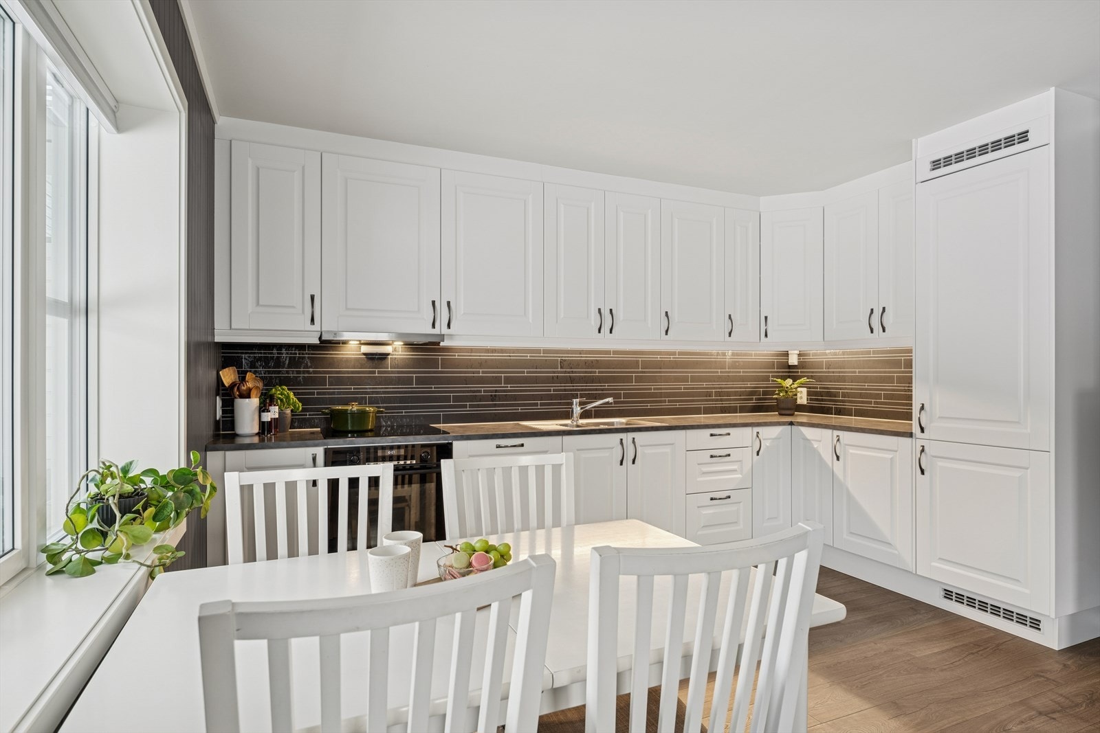 Over benkeplaten er det montert kjøkkenplater på bakveggen, og det er belysning under overskapene. Galleribilde