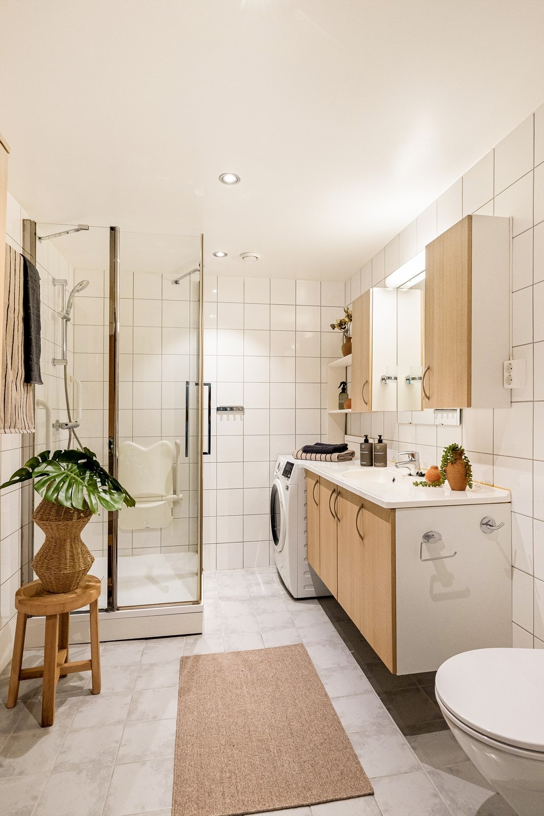 Badet er innredet med nedfelt servant med rom for oppbevaring i underskap, speil med belysning, vegghengt toalett og dusjhjørne. Galleribilde