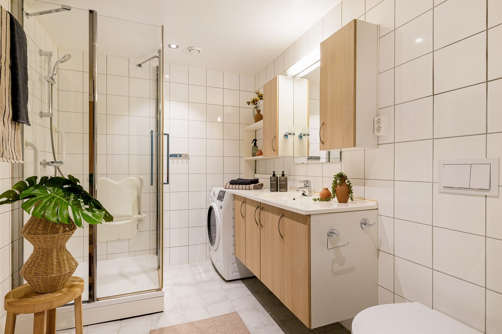 Badet er pent innredet med lyse fliser og har varmekabler i gulv. Galleribilde