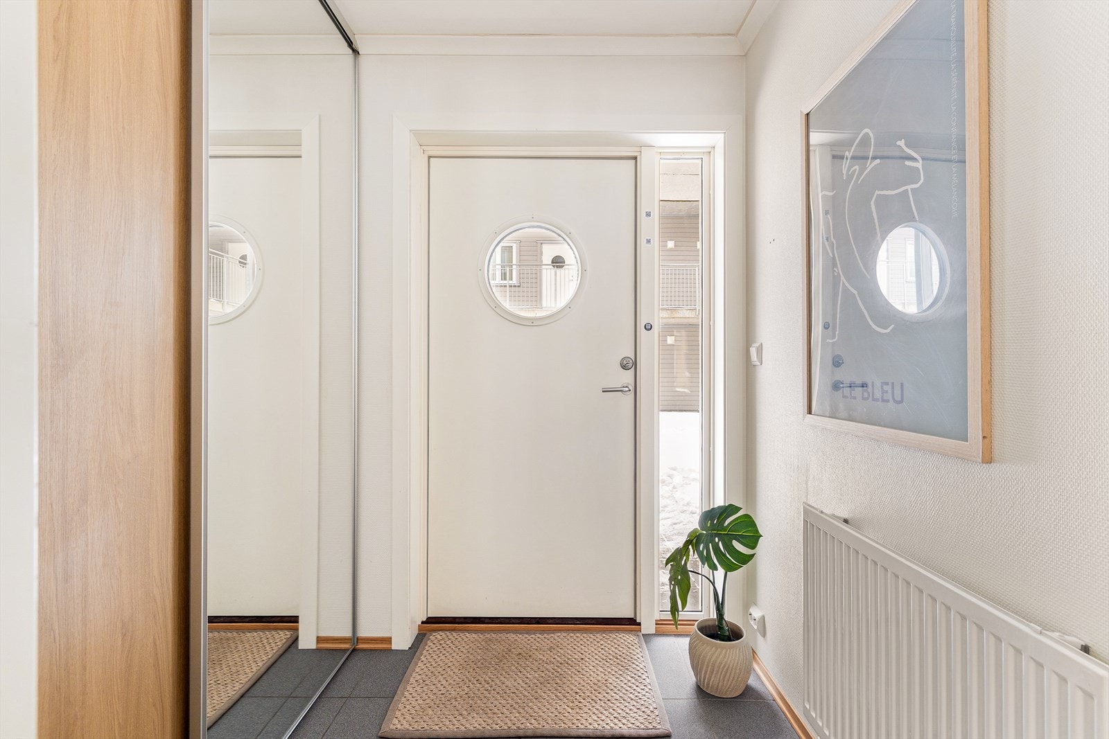 Velkommen inn til en romslig flislagt entré med god plass til oppheng for yttertøy og til å sette ifra seg sko, i skyvedørsgarderobe. Galleribilde