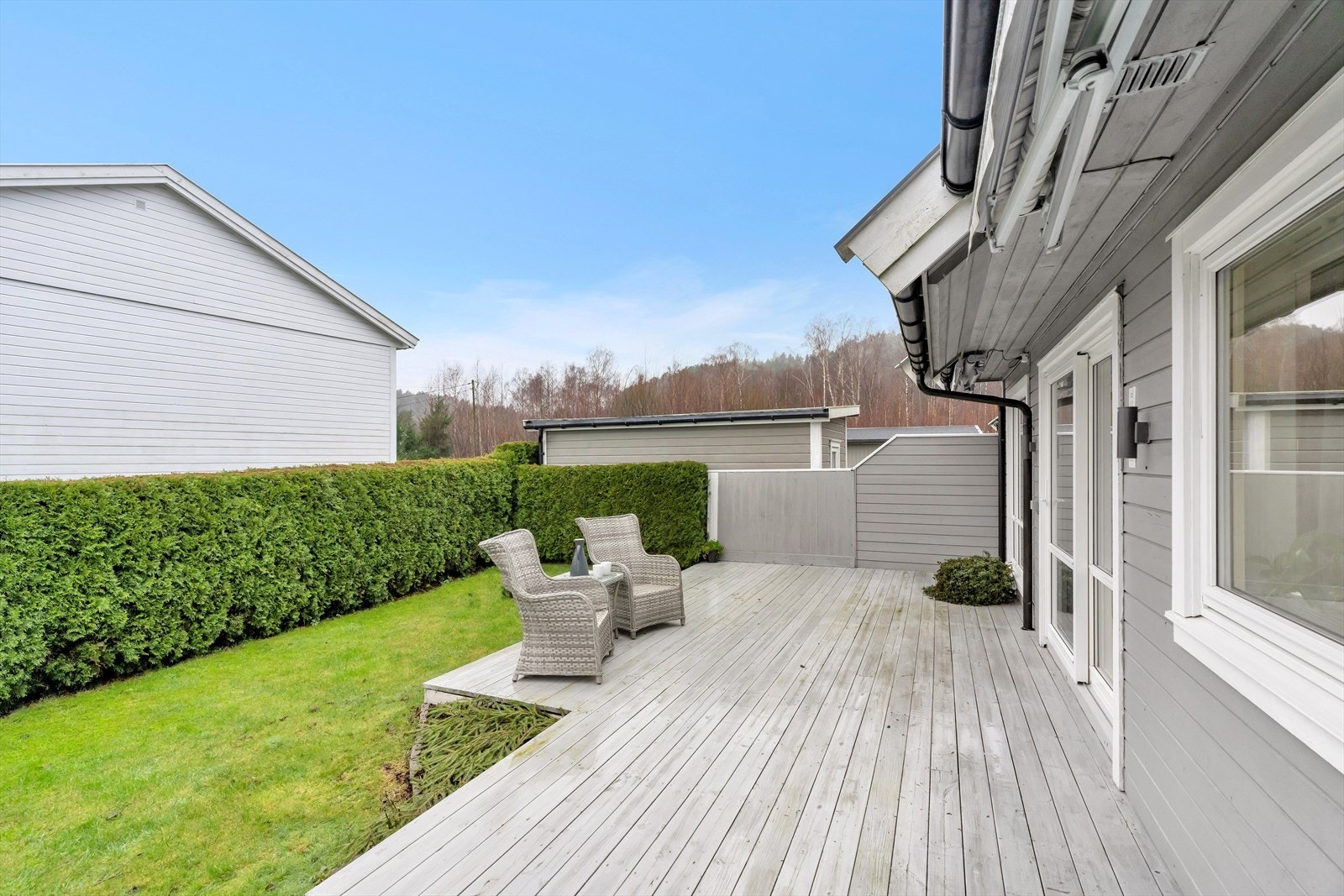 Området er pent opparbeidet med busker, beplantning og blomsterbed som gir en innbydende atmosfære. Galleribilde