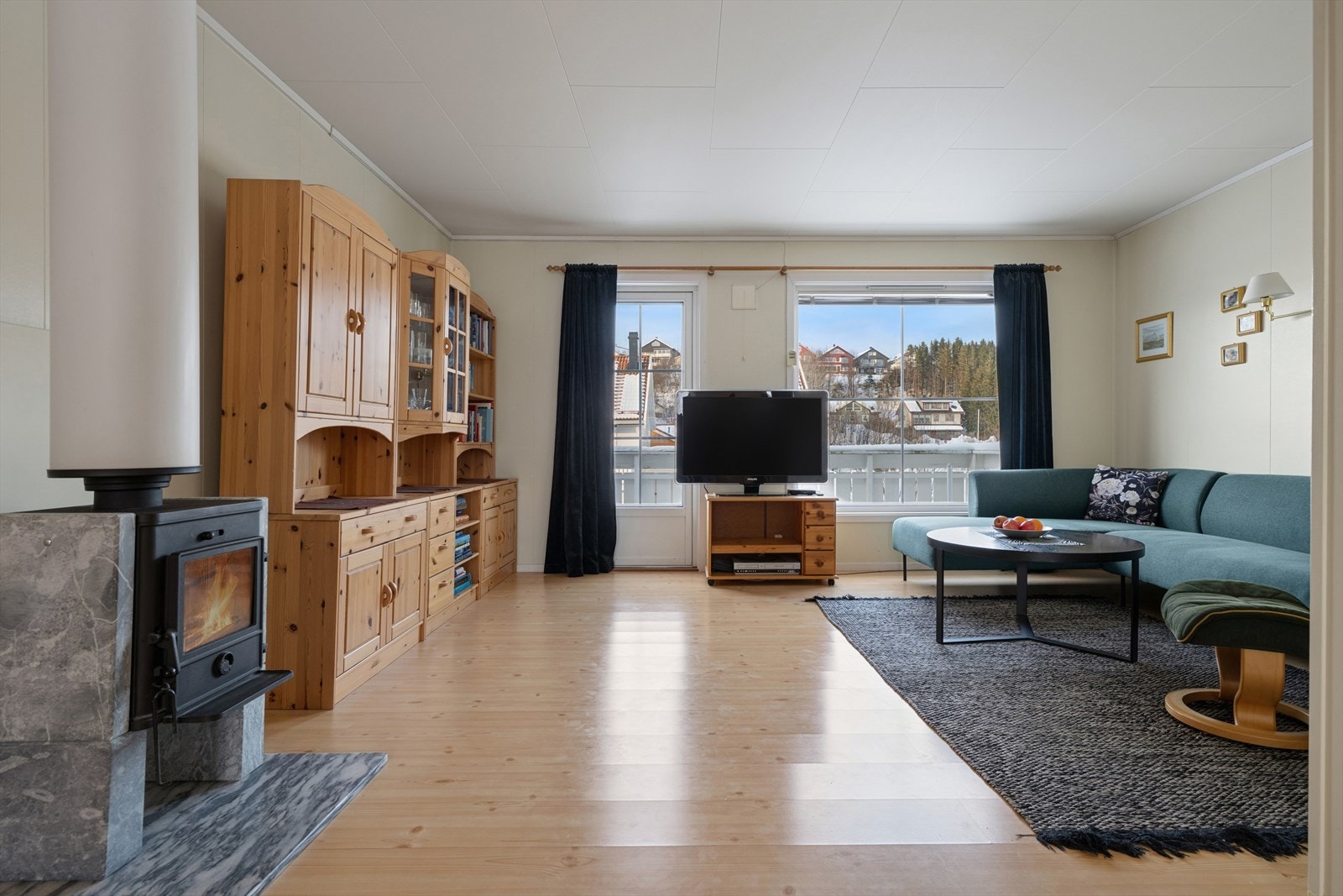 Stuen i andre etasje er et romslig samlingspunkt, med vedovn for effektiv oppvarming. Galleribilde