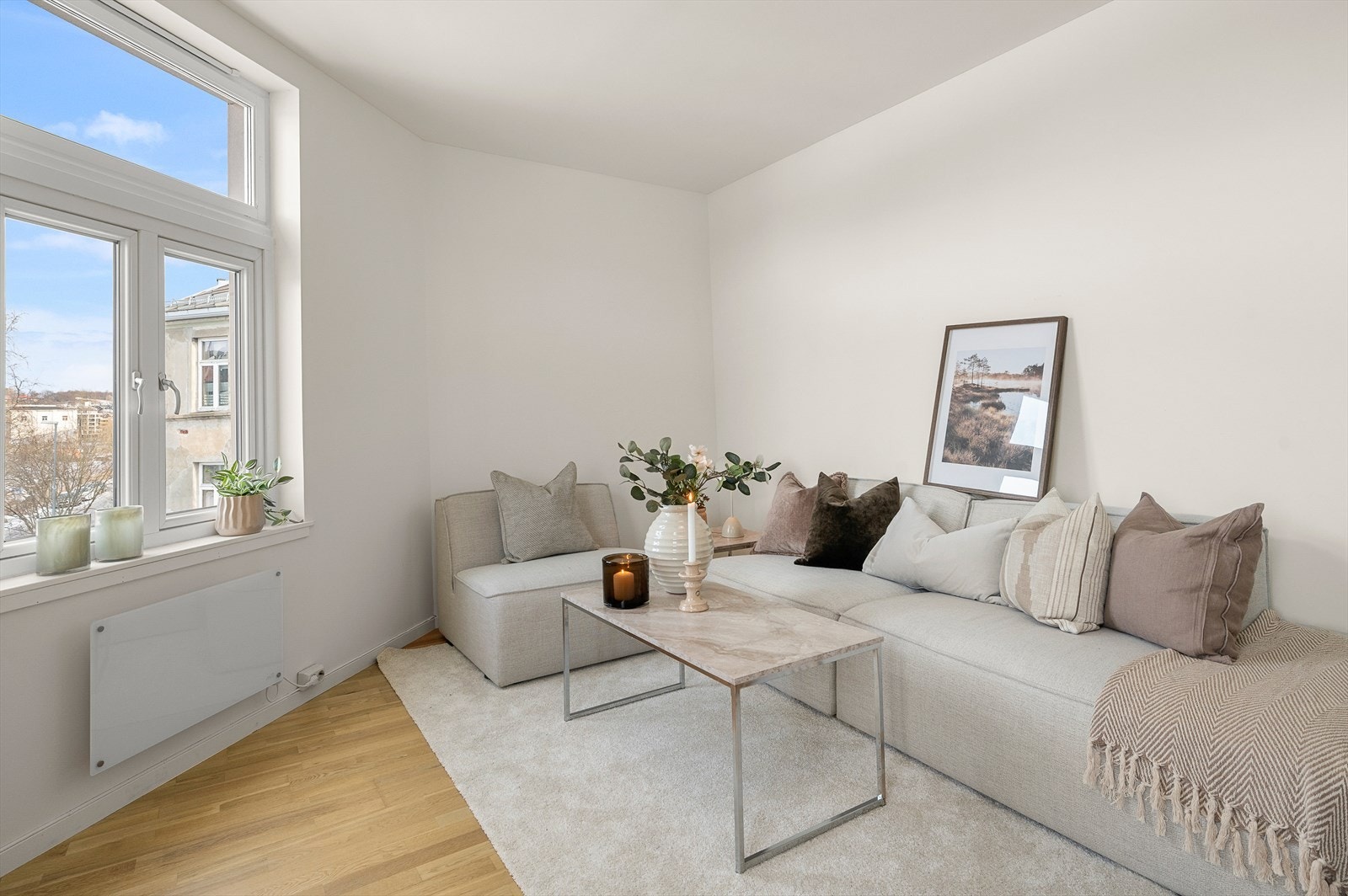 Leiligheten oppleves lys og luftig med god takhøyde og store vindusflater som slipper inn dagslys Galleribilde