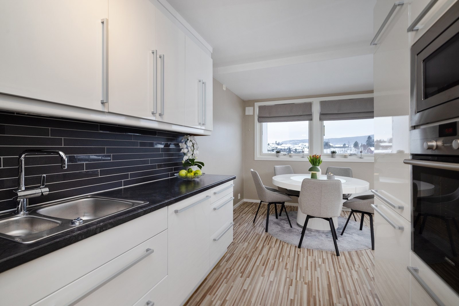 Kjøkkeninnredning med glatte, høyglansede fronter og rikelig med oppbevaringsplass. Galleribilde