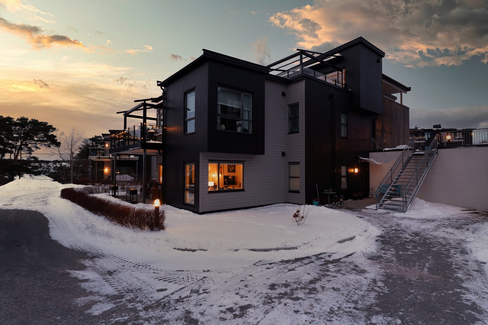 Til høyre for trappen foran inngangspartiet finnes bakdør til garasjeanlegget, der leiligheten disponerer både bod og biloppstillingsplass. Galleribilde